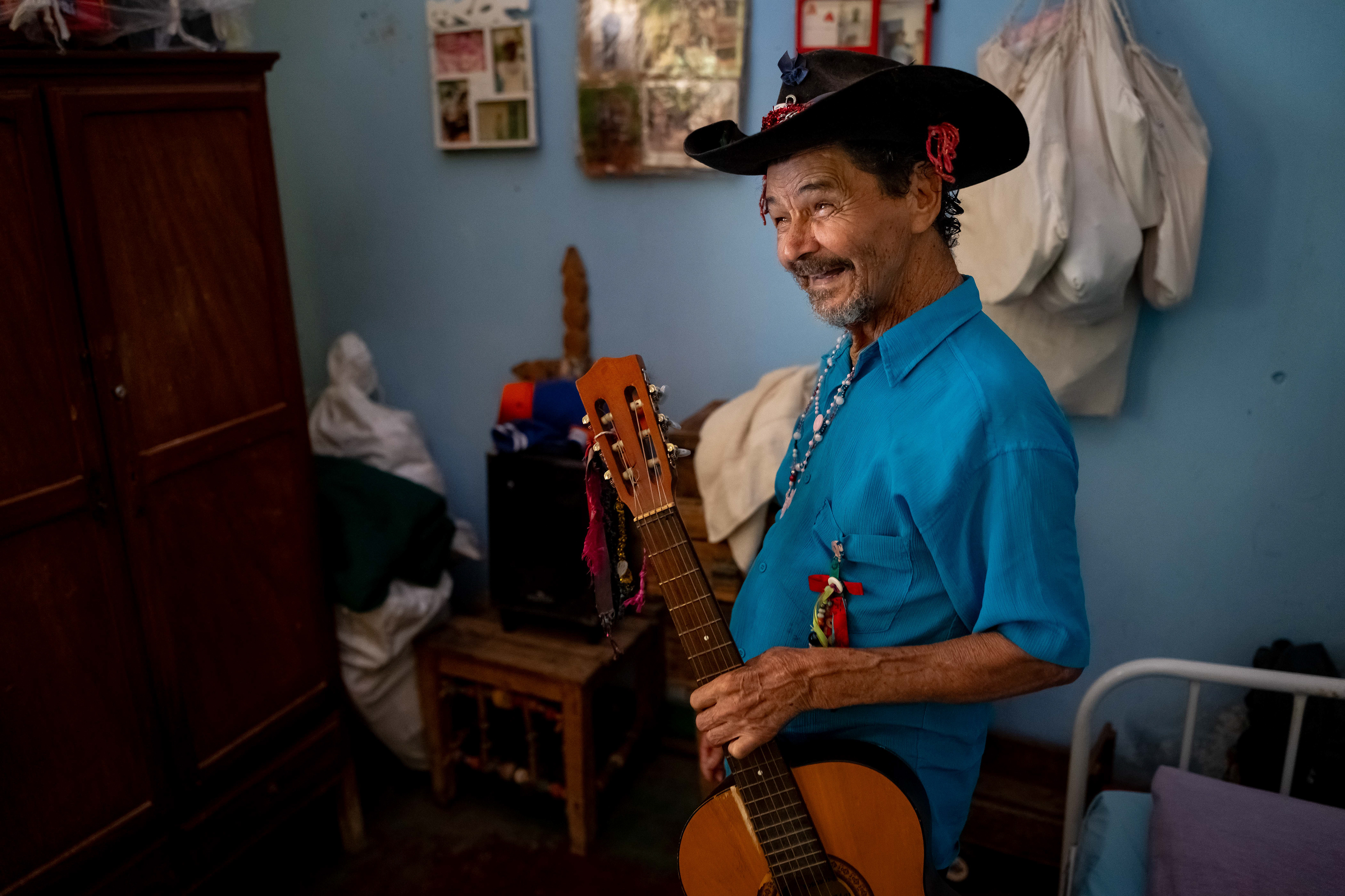 Pipa holds his guitar in his room at the Saint Vincent de Paul Home in Cidade de Goiás, Go., Friday, March 6, 2026. Living with an intellectual disability, he often turns to music as a way to spend his time. (© Camden Hall)