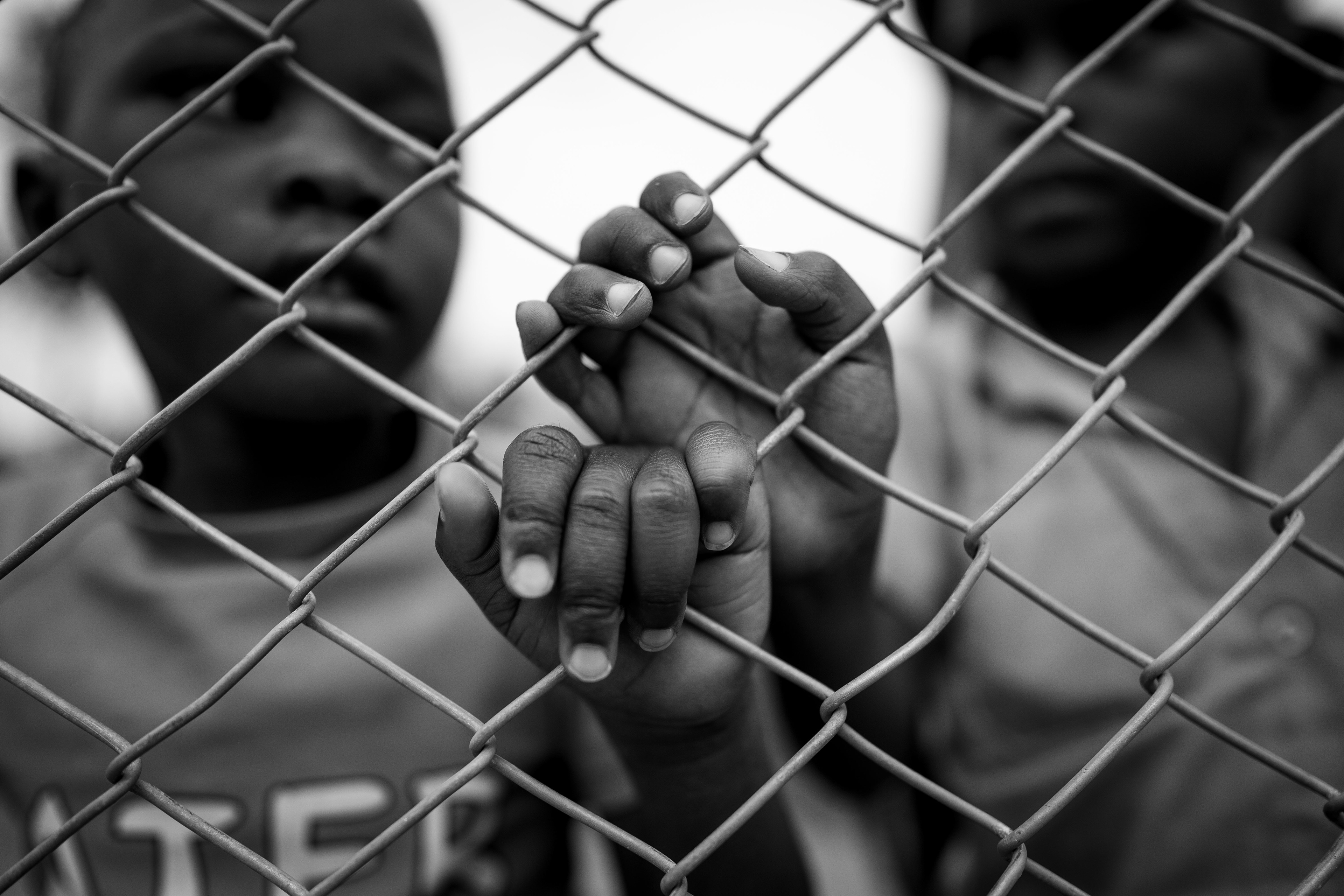 Children line the fence to watch a basketball game between Riviera High School and the Hope Haven School at the Hope Haven School near the Murindi Village in Kigali, Rwanda, Sunday, March 9, 2025. 