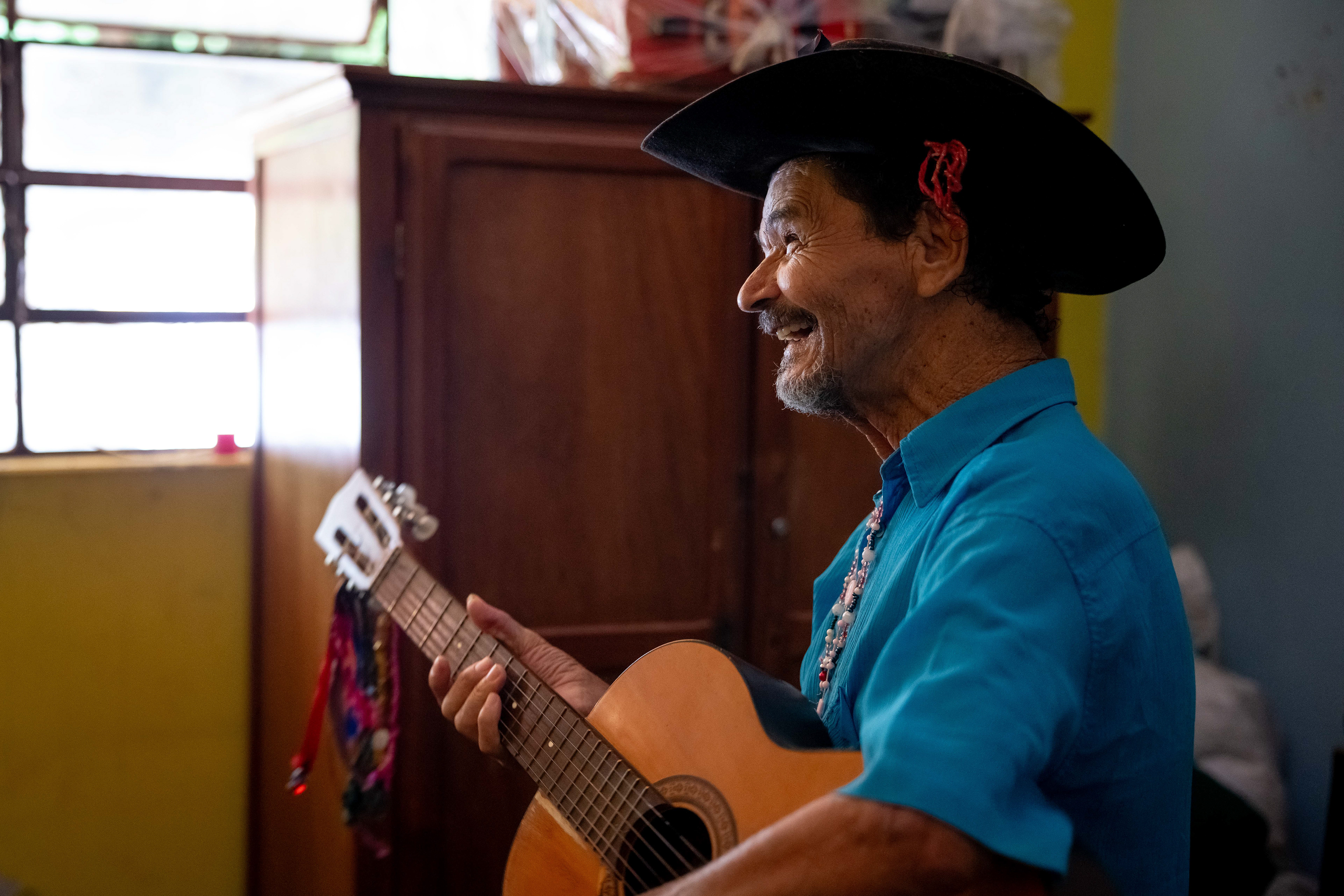 Pipa plays his guitar in his room at the Saint Vincent de Paul Home in Cidade de Goiás, Go., Friday, March 6, 2026. Living with an intellectual disability, he often turns to music as a way to spend his time. (© Camden Hall)