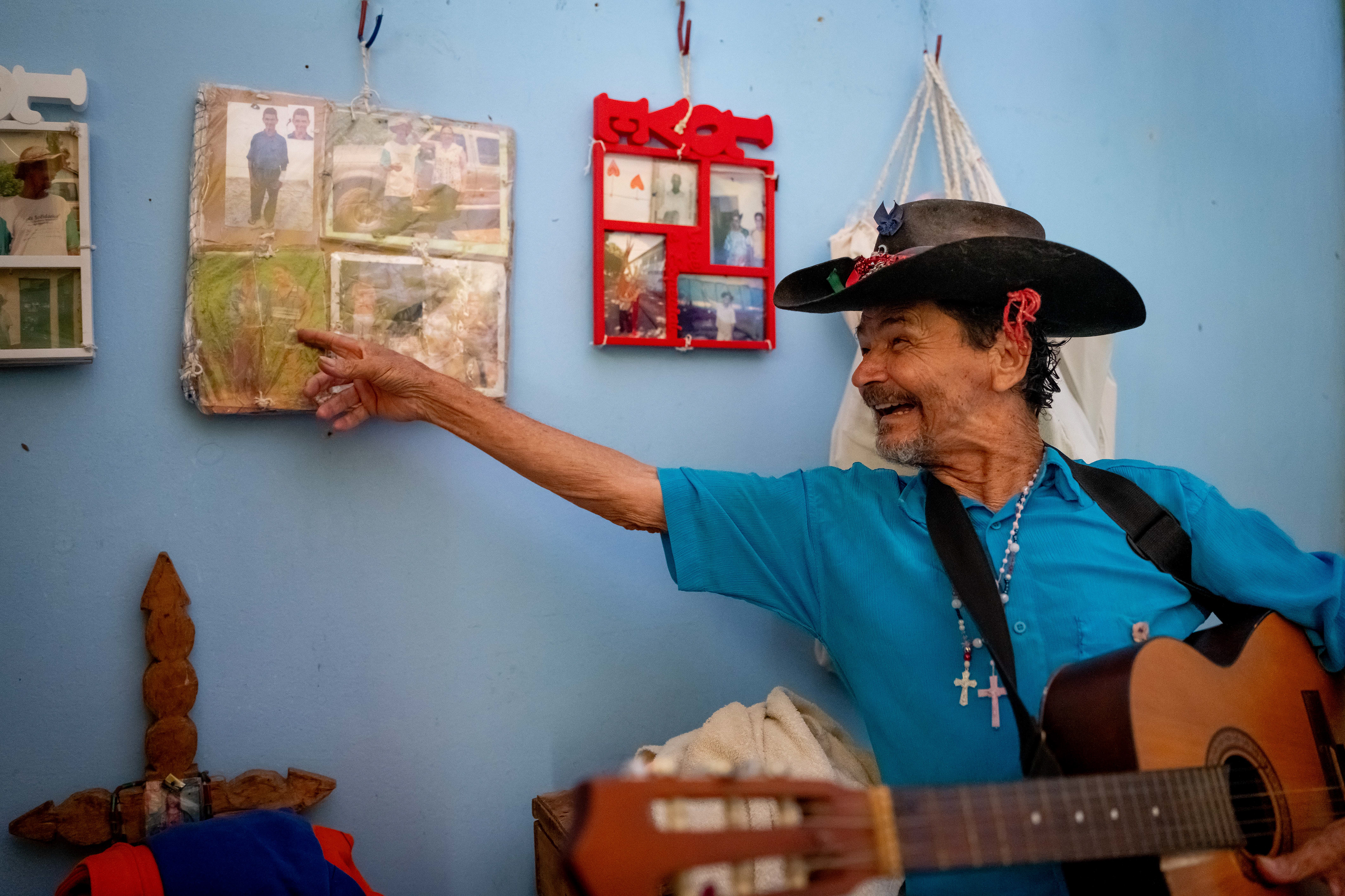 Pipa points to old photographs of himself displayed on the wall of his at the Saint Vincent de Paul Home in Cidade de Goiás, Go., Friday, March 6, 2026. Living with an intellectual disability, he often turns to music as a way to spend his time.