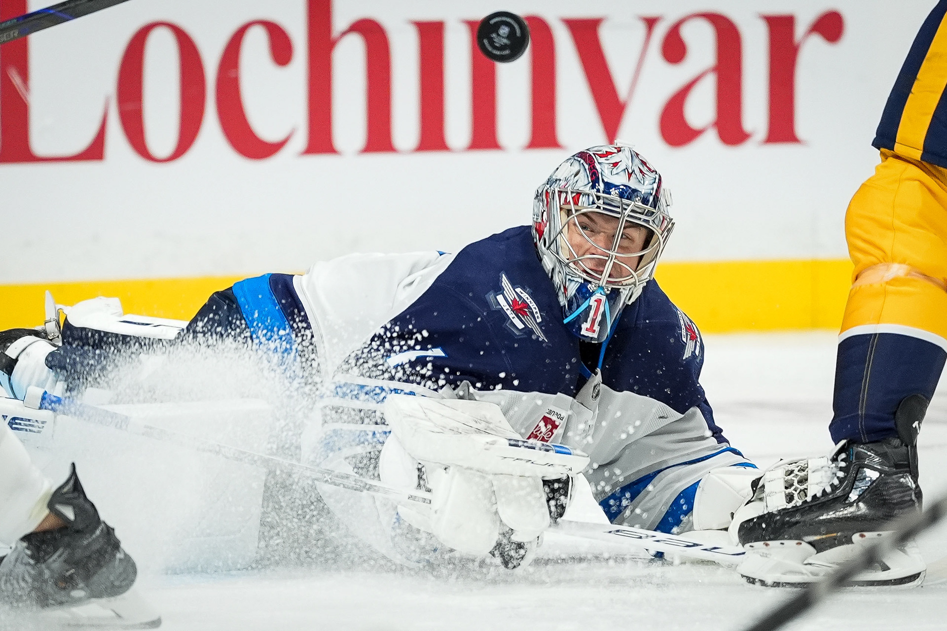 Winnipeg Jets goaltender Eric Comrie (1) attempts to block a shot on goal during the third period of his NHL hockey game against the Nashville Predators at Bridgestone Arena in Nashville, Tenn., Saturday, Nov. 23, 2024.