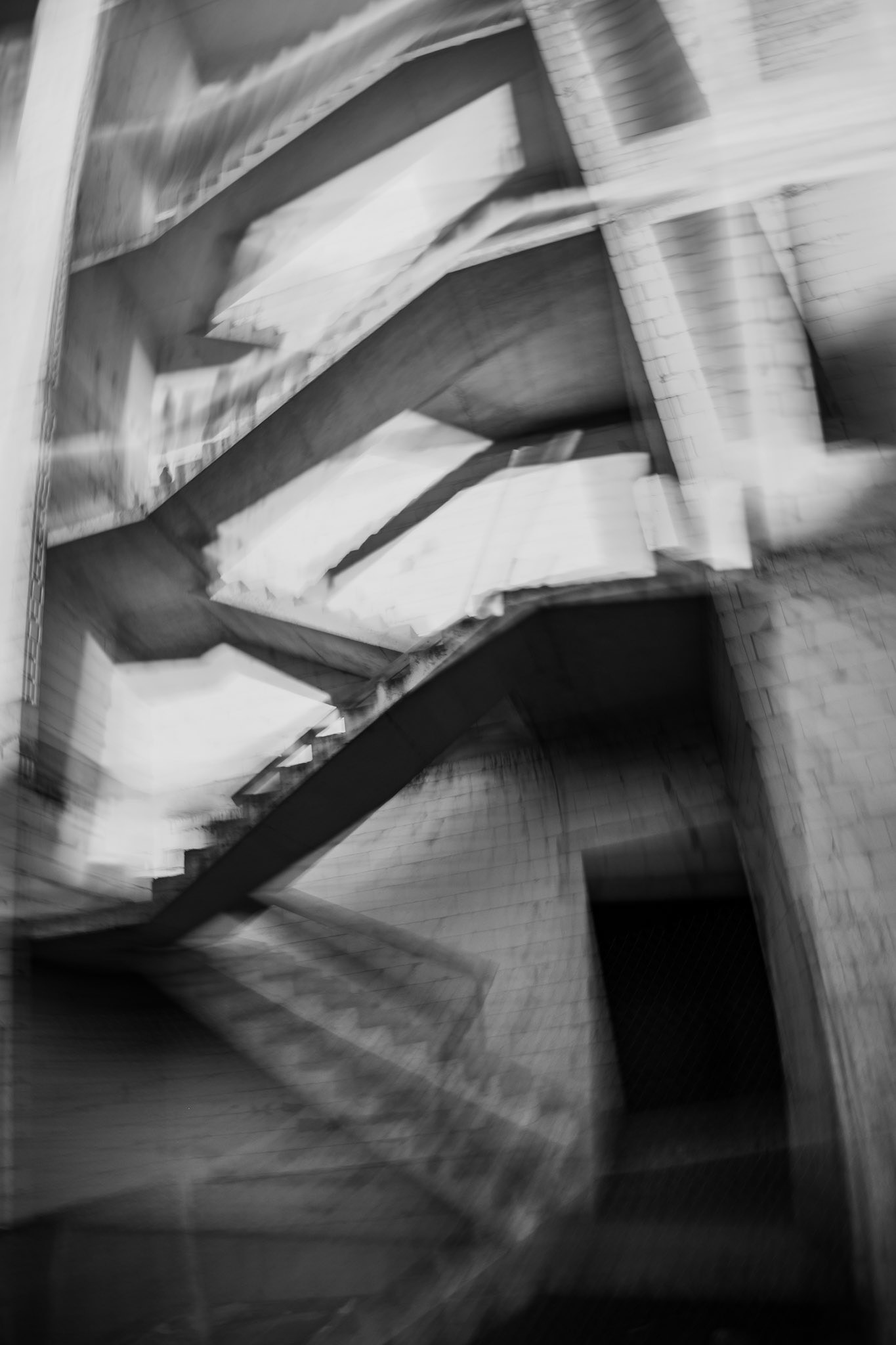 Ethereal monochrome architectural study of a stairwell in motion.