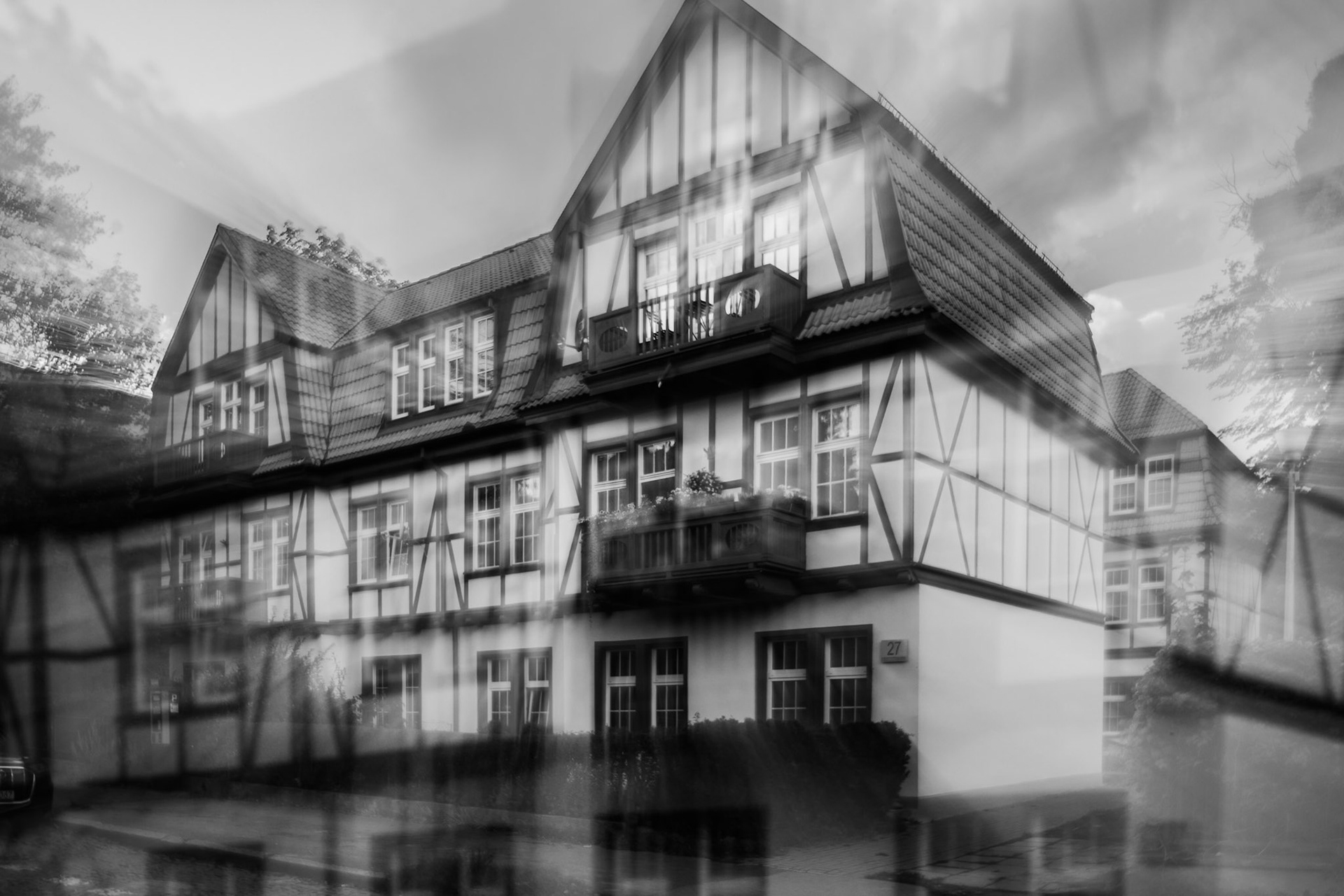 Traditional half-timbered house with gabled roof, black and white architectural photography in ICM technique.