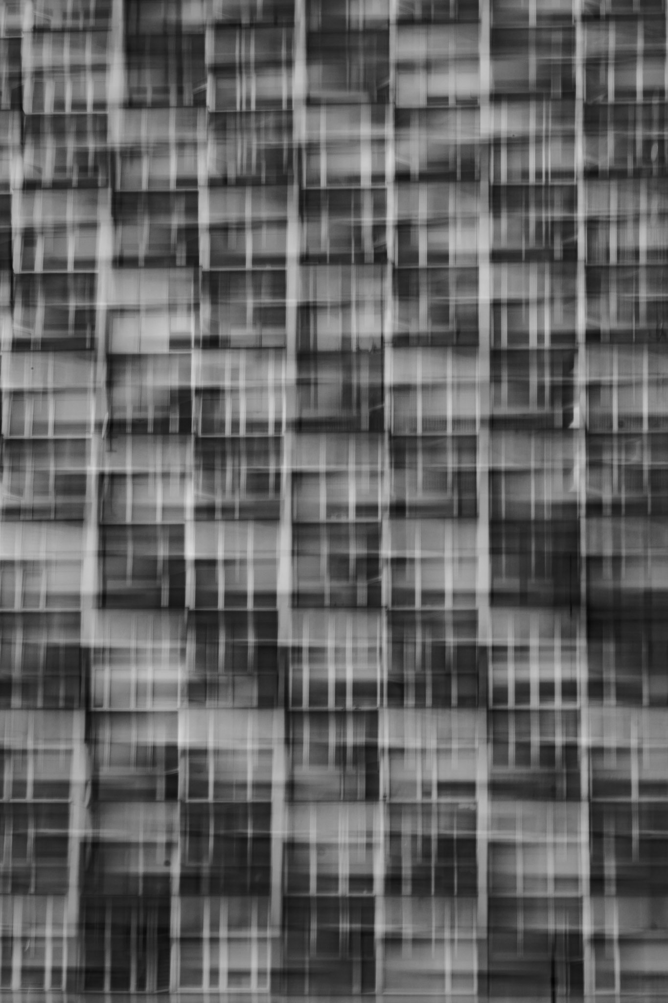 Abstract grayscale texture featuring overlapping rectangular shapes and blurred grid lines in a modern geometric style.