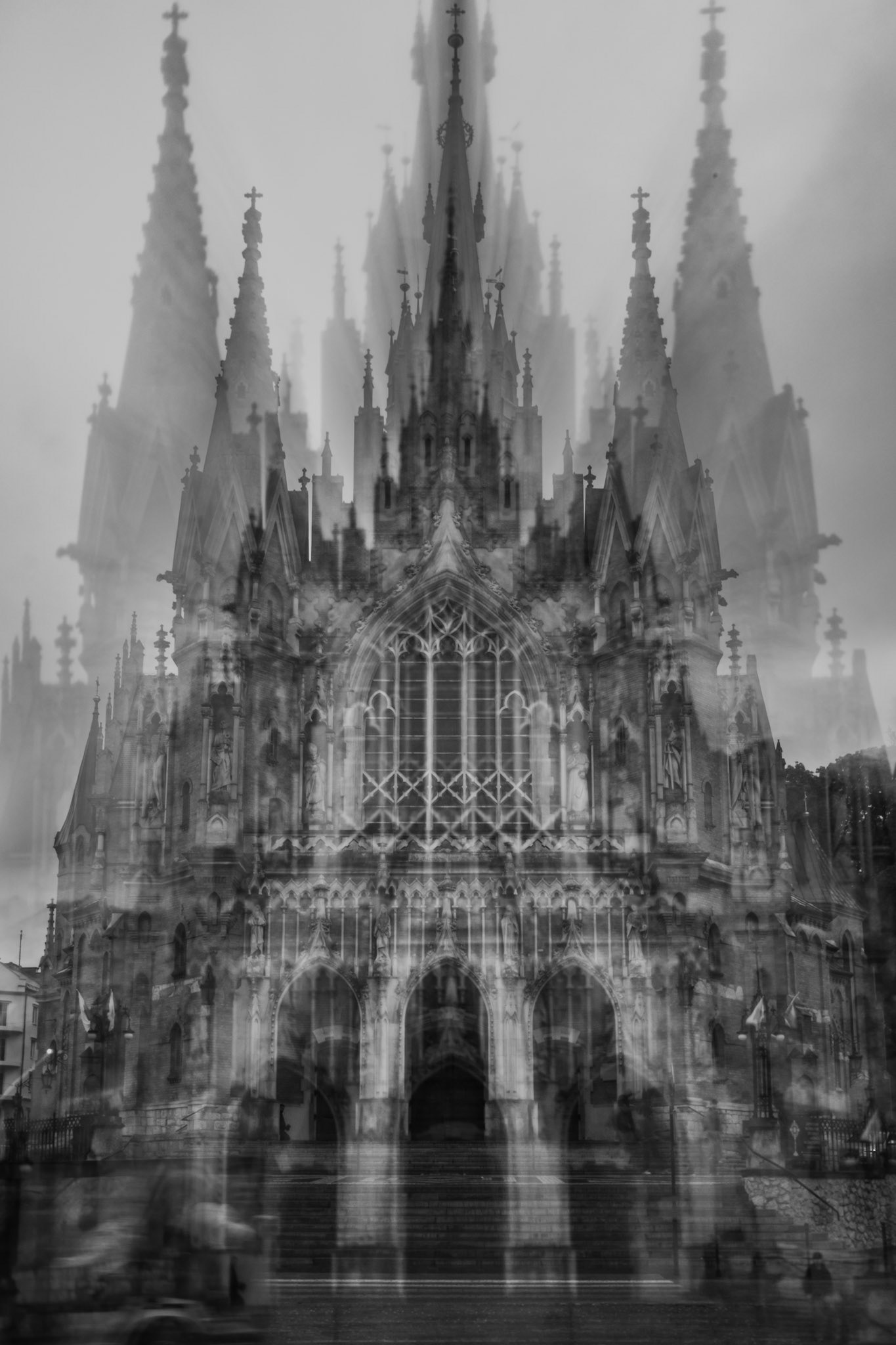 Black-and-white abstract photograph of a Gothic cathedral with layered double-exposure effect, towering spires, blurred motion, and haunting symmetrical architecture.
