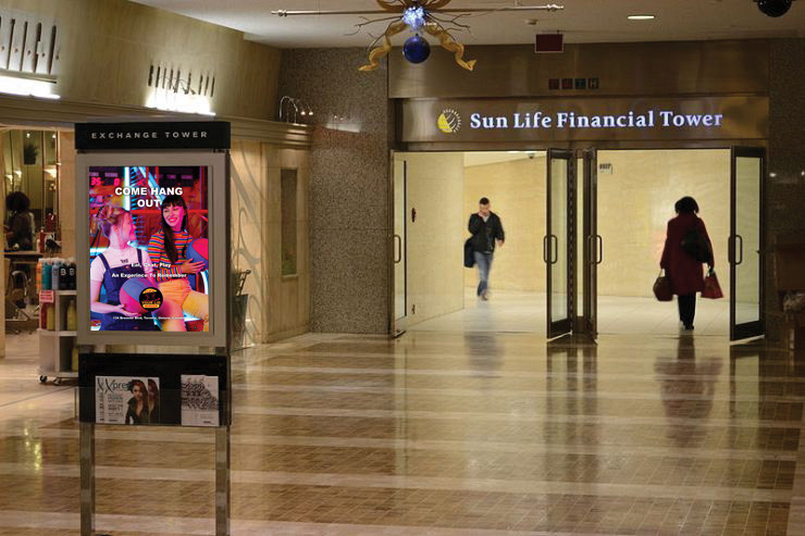 In this image is an advertisement that will be placed in the Underground Pathway where two female friends are chatting and holding a basketball where they are also playing a game at the restaurant. The words Come Hang Out, Eat, Chat, Play, An Experience To Remember and the location of the restaurant all in a white colour. The Flip'N Your Lid Burger logo is located at the bottom of the advertisement, but above the restaurant's street location in the ad.