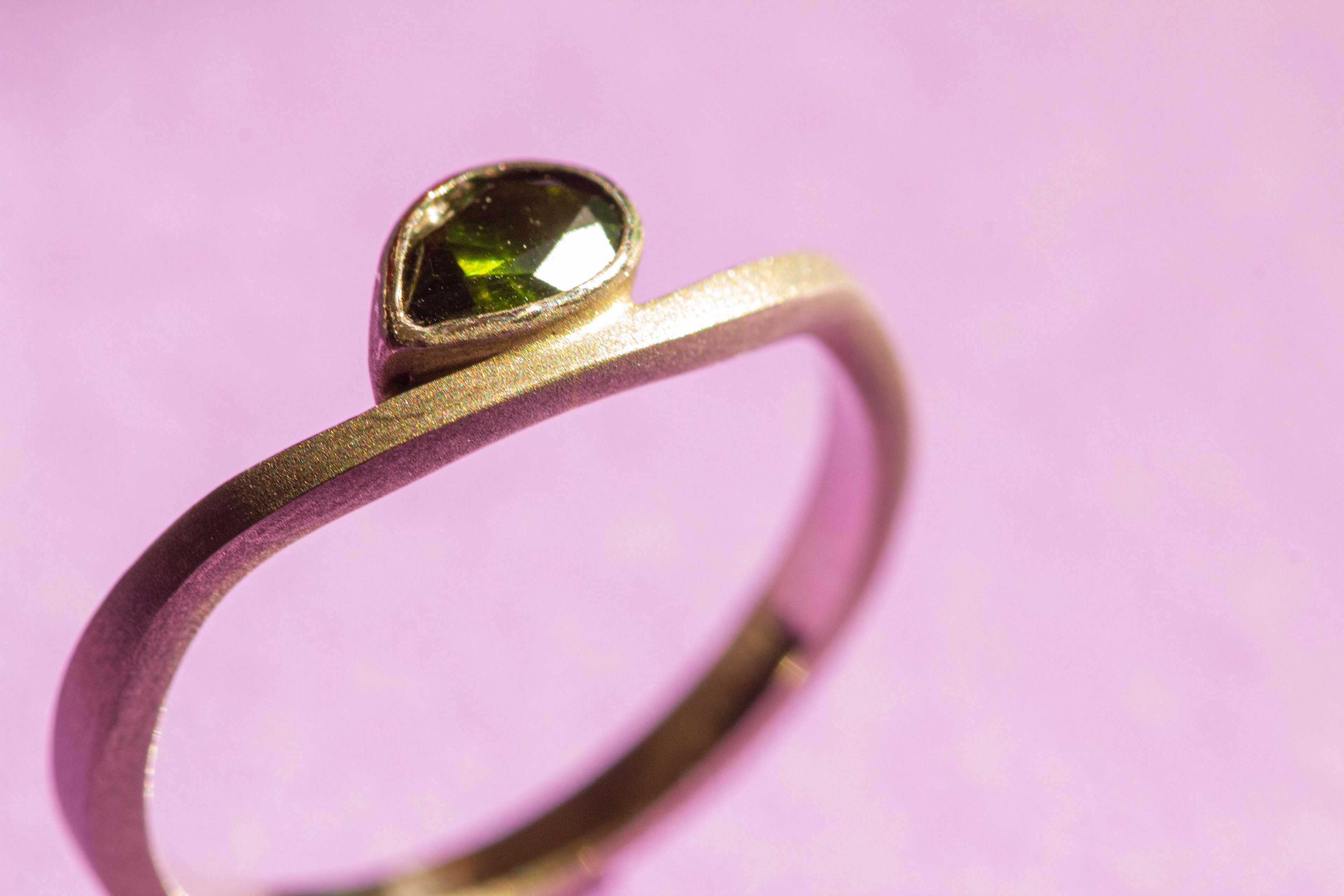 White gold ring with a natural pear cut green tourmaline.