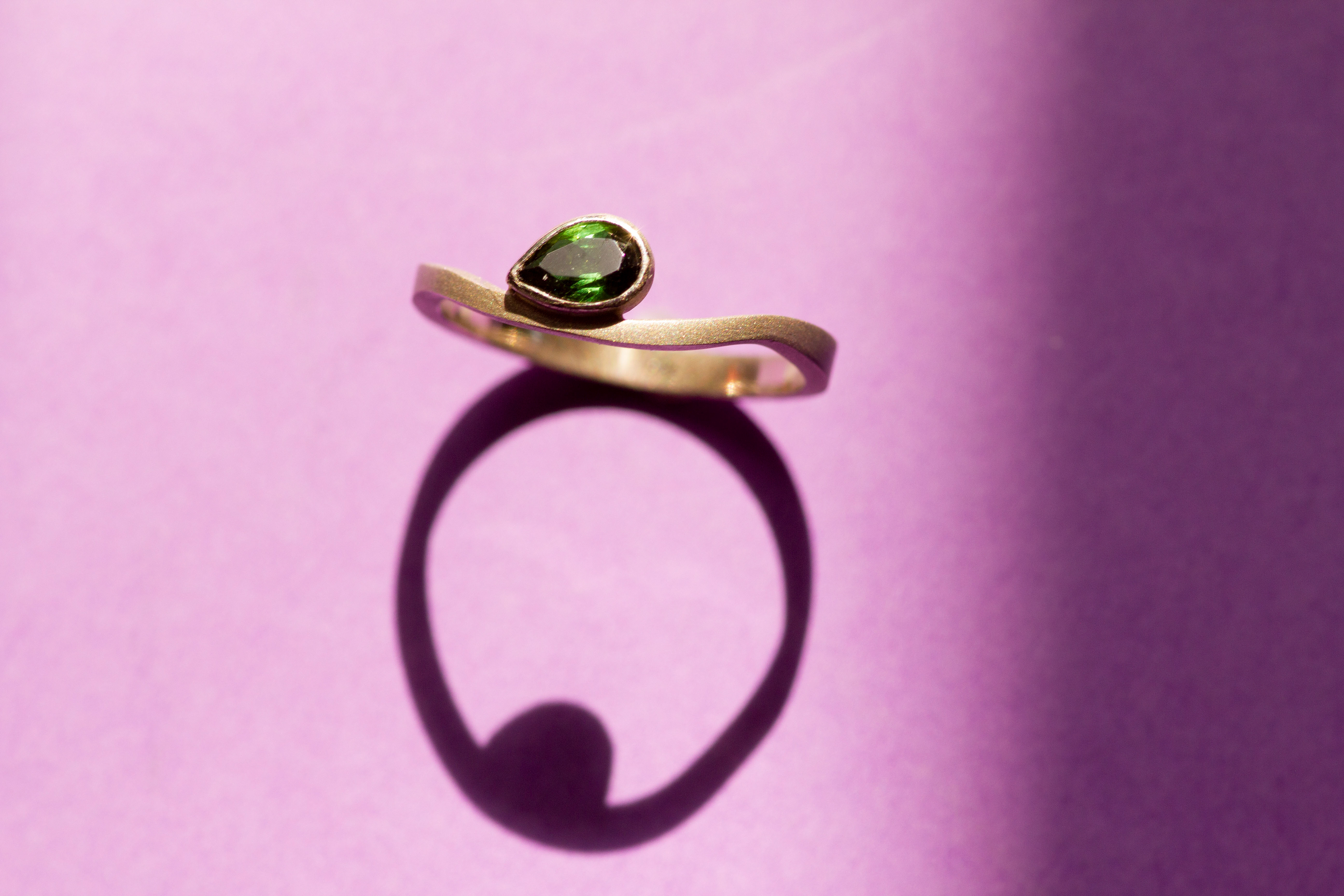 White gold ring with a natural pear cut green tourmaline.