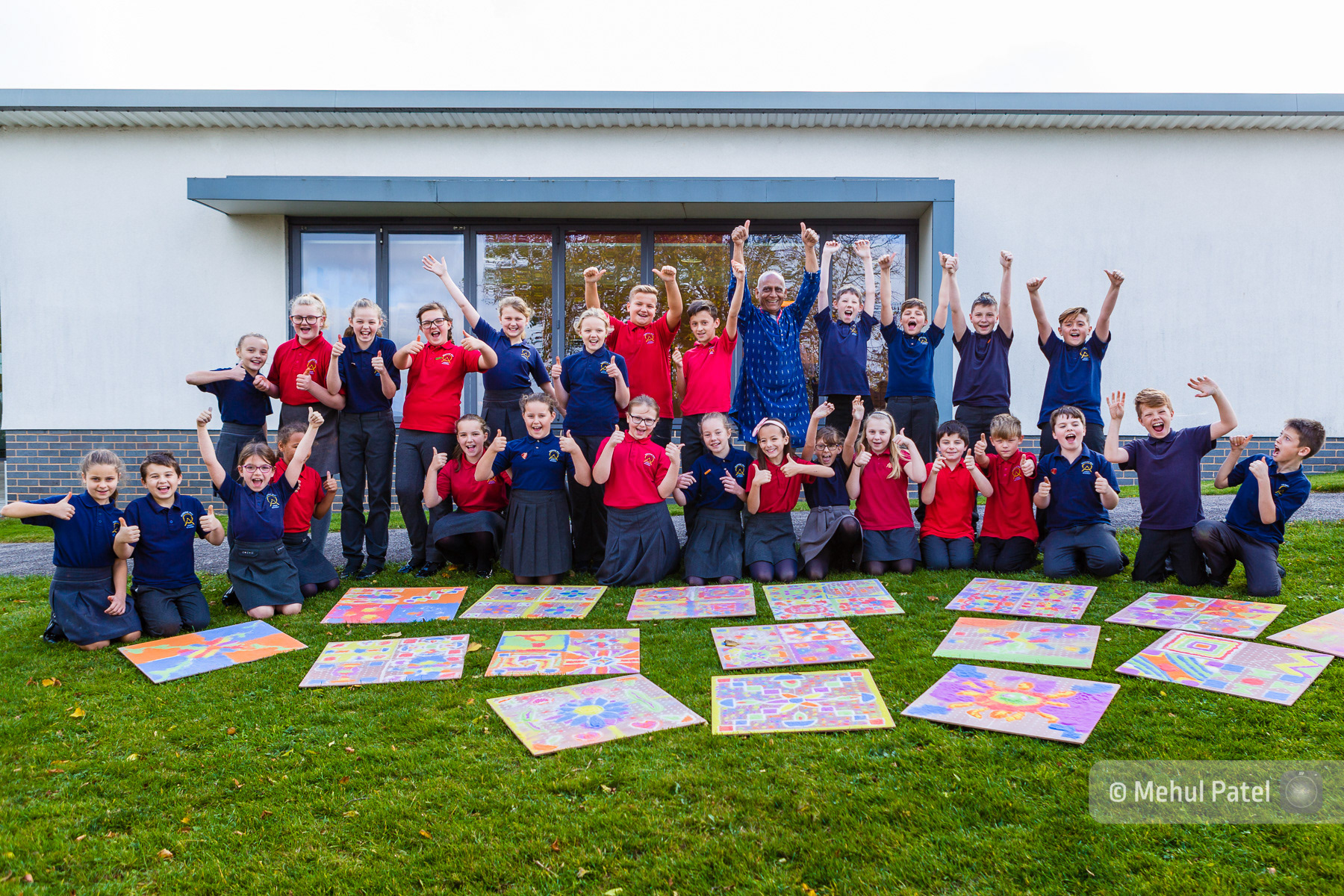 Children at school celebrating completion of rangoli pattern artwork. Published on client website and in booklet