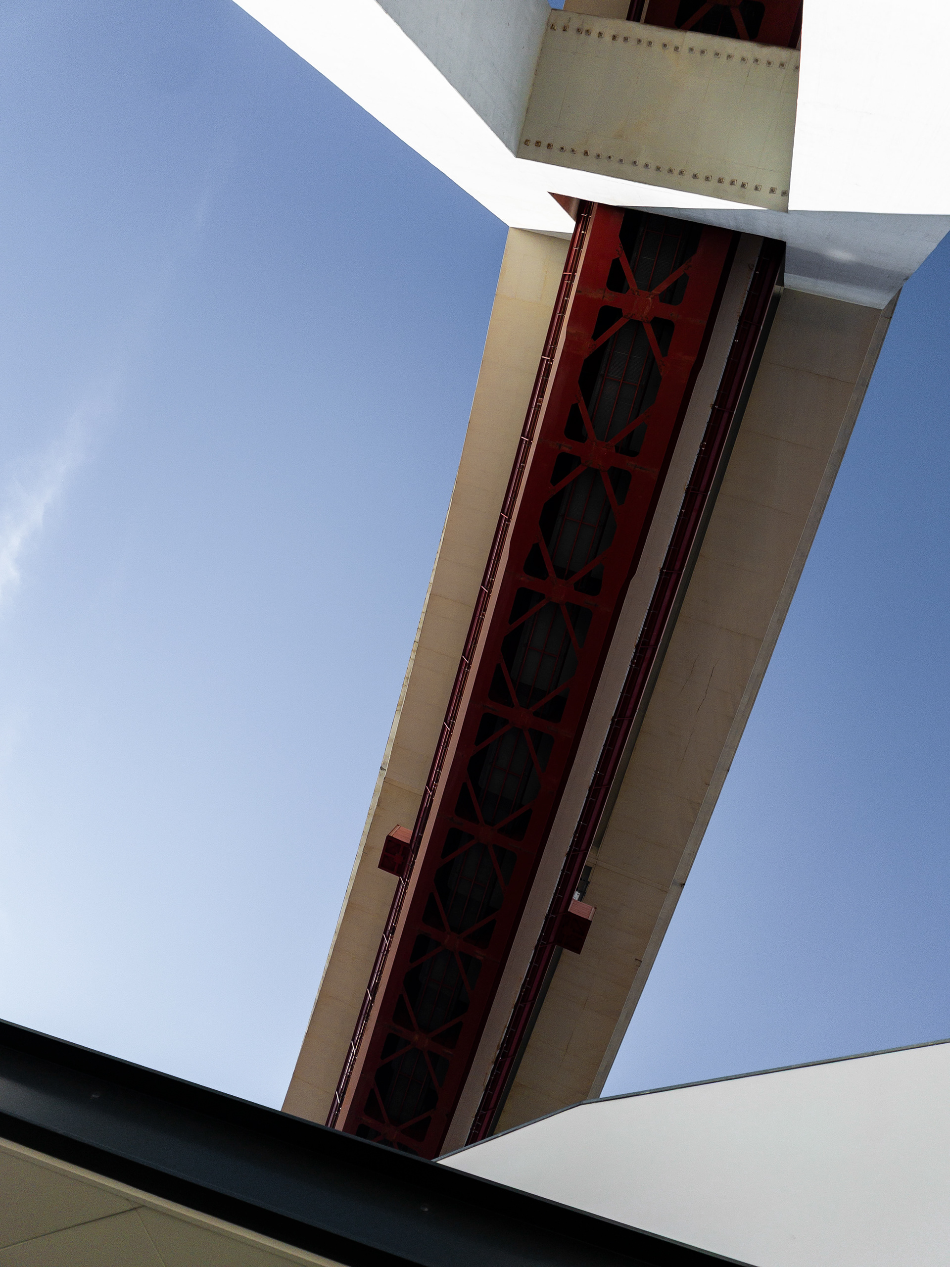 The 25 de Abril bridge seen from below forms an abstract geometric pattern