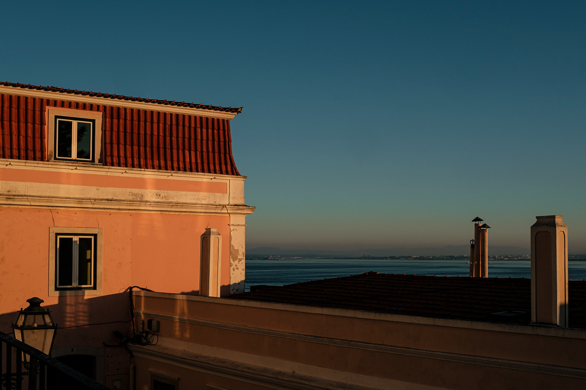 A salmon-painted wall and a blue sky at sunset hour