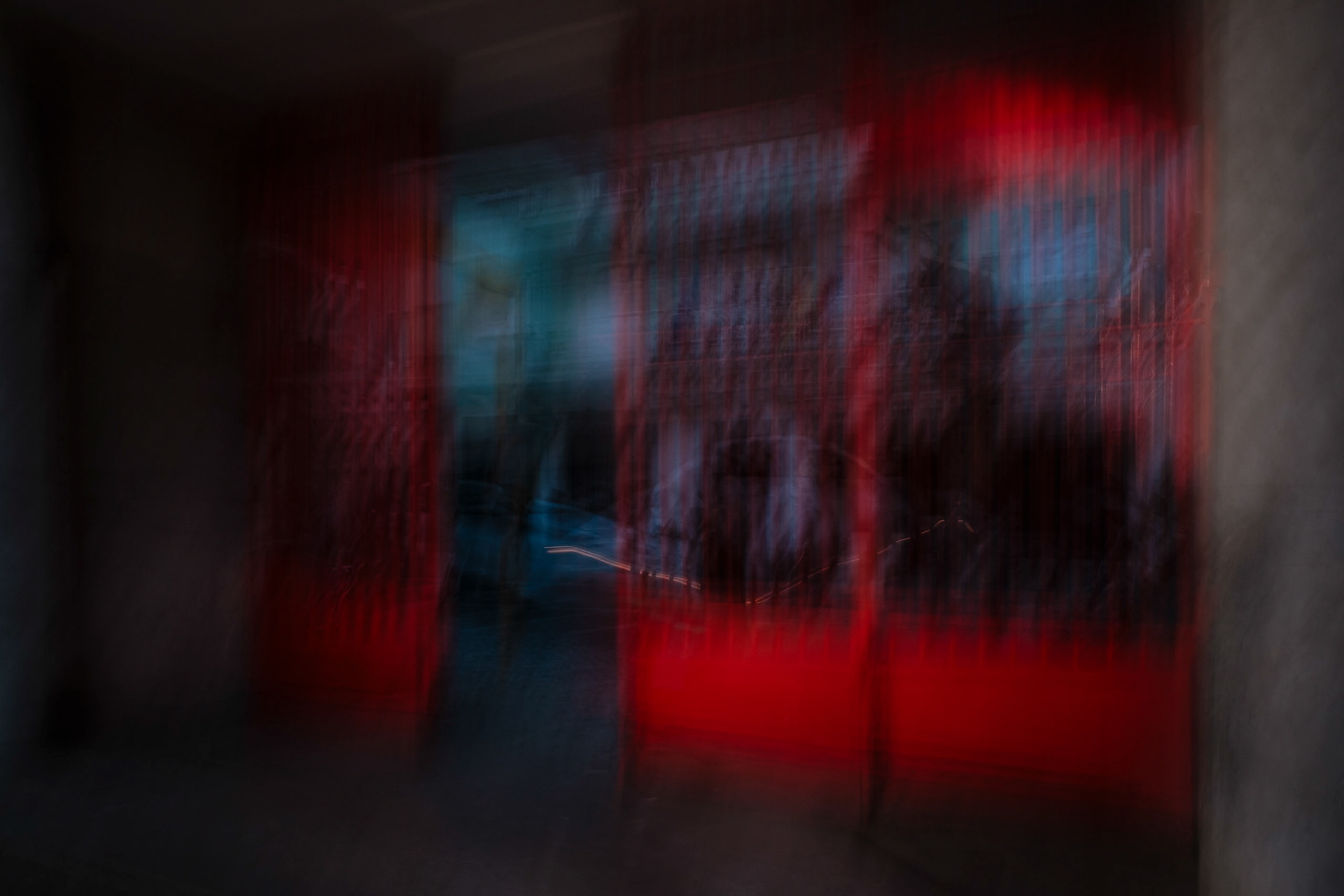 an intentional camera movement view of a red gate at the entrance of a market