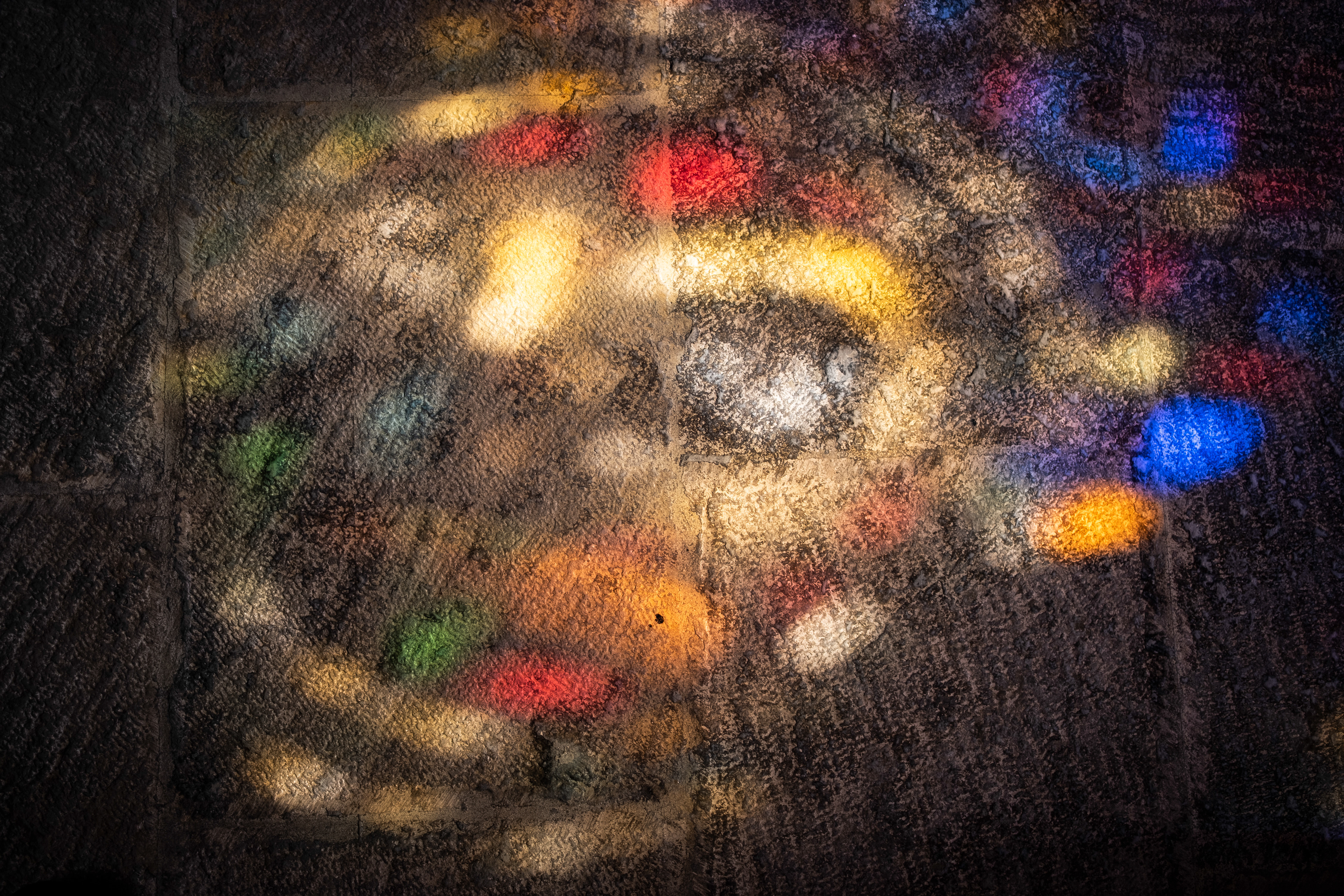 Reflection of Lisbon's Cathedral's tainted windows against the ground of the religious edifice