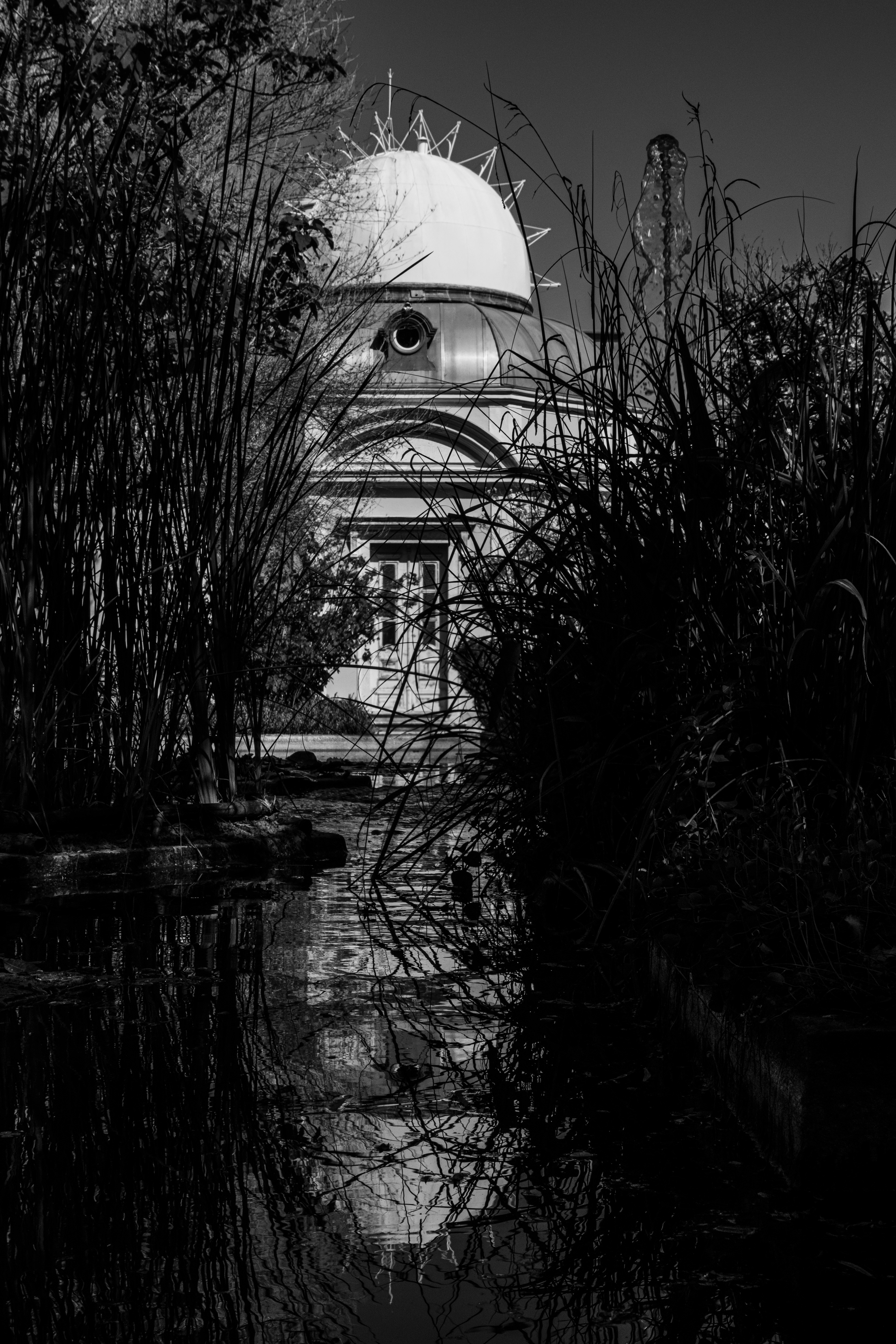 Black and white image of the astronomic observatory reflected in a pool in Lisbon