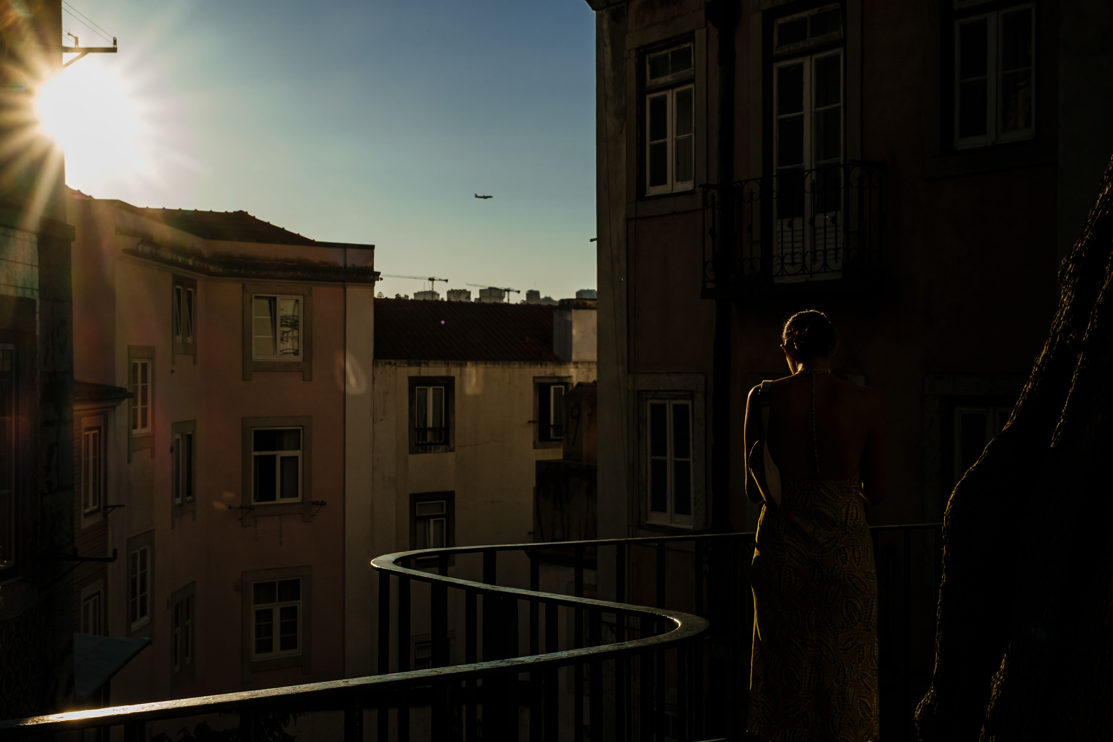 The silhouette of a woman is drawn out of the shadow by the sunlight that also illuminates a handrail, in central Lisbon.