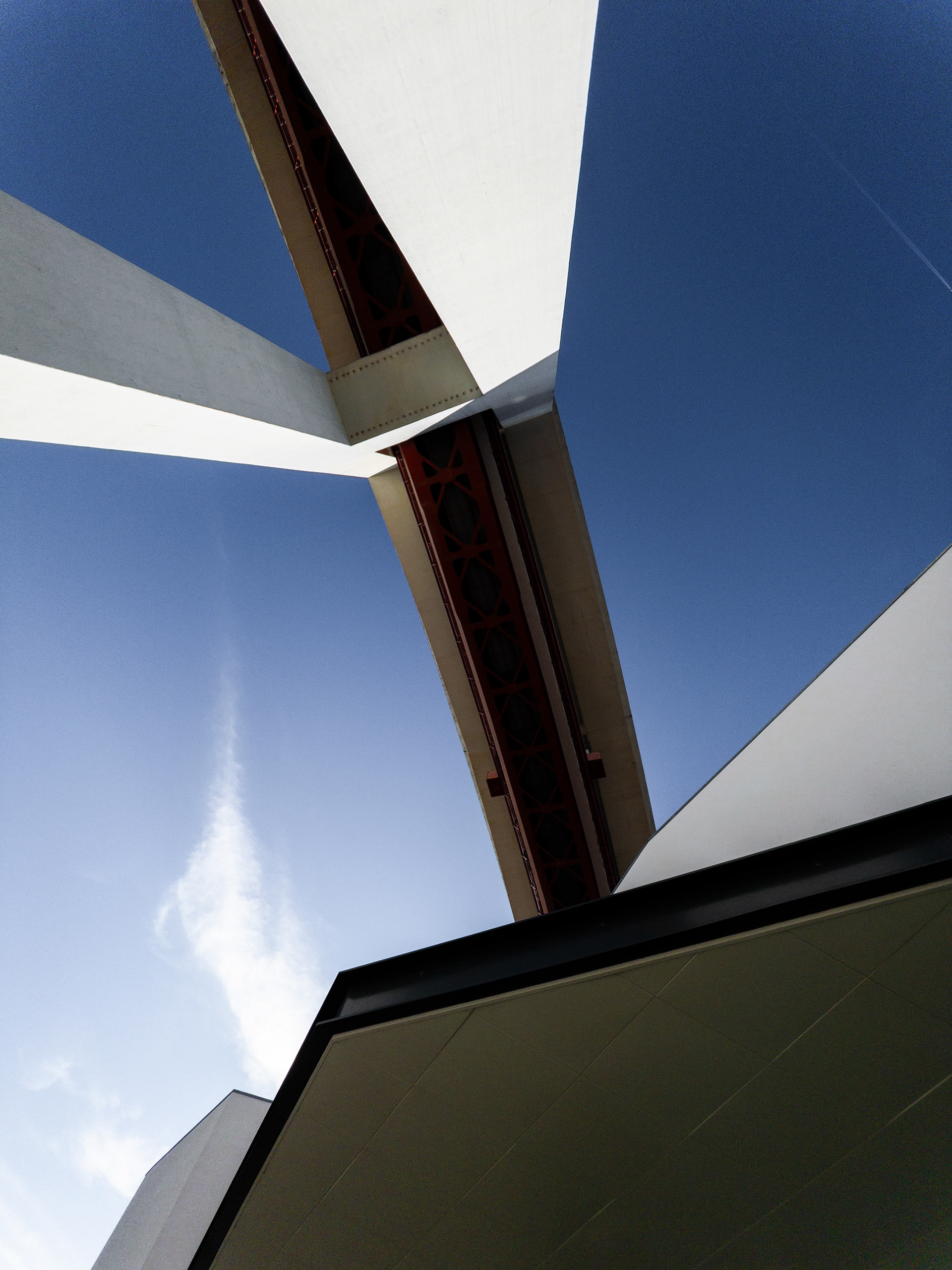 The 25 de Abril bridge seen from below forms an abstract geometric pattern