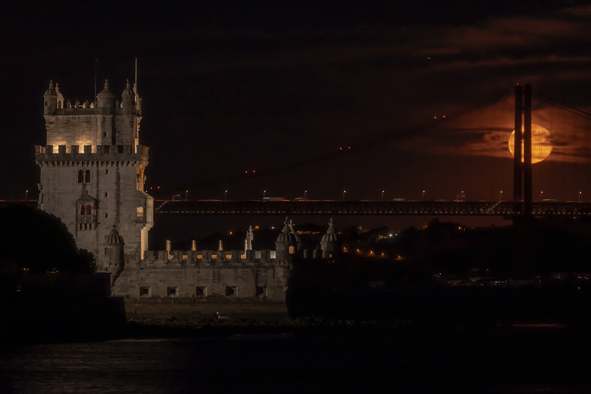 the full moon over the torre de Belém and the 25 de Abril bridge