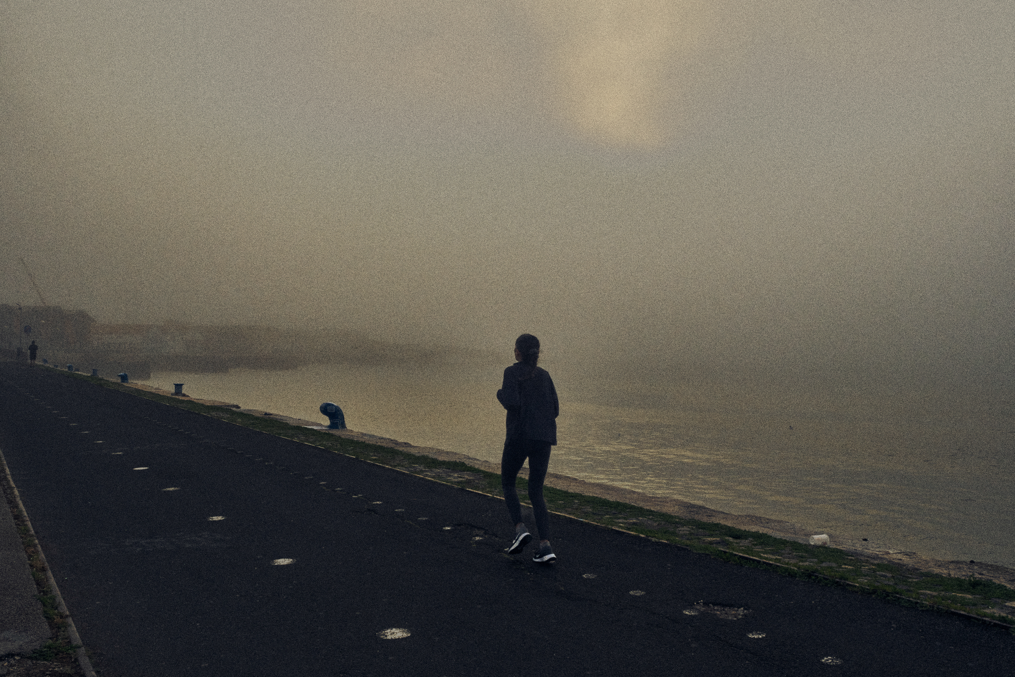 A runner in the morning fog over the river Tejo