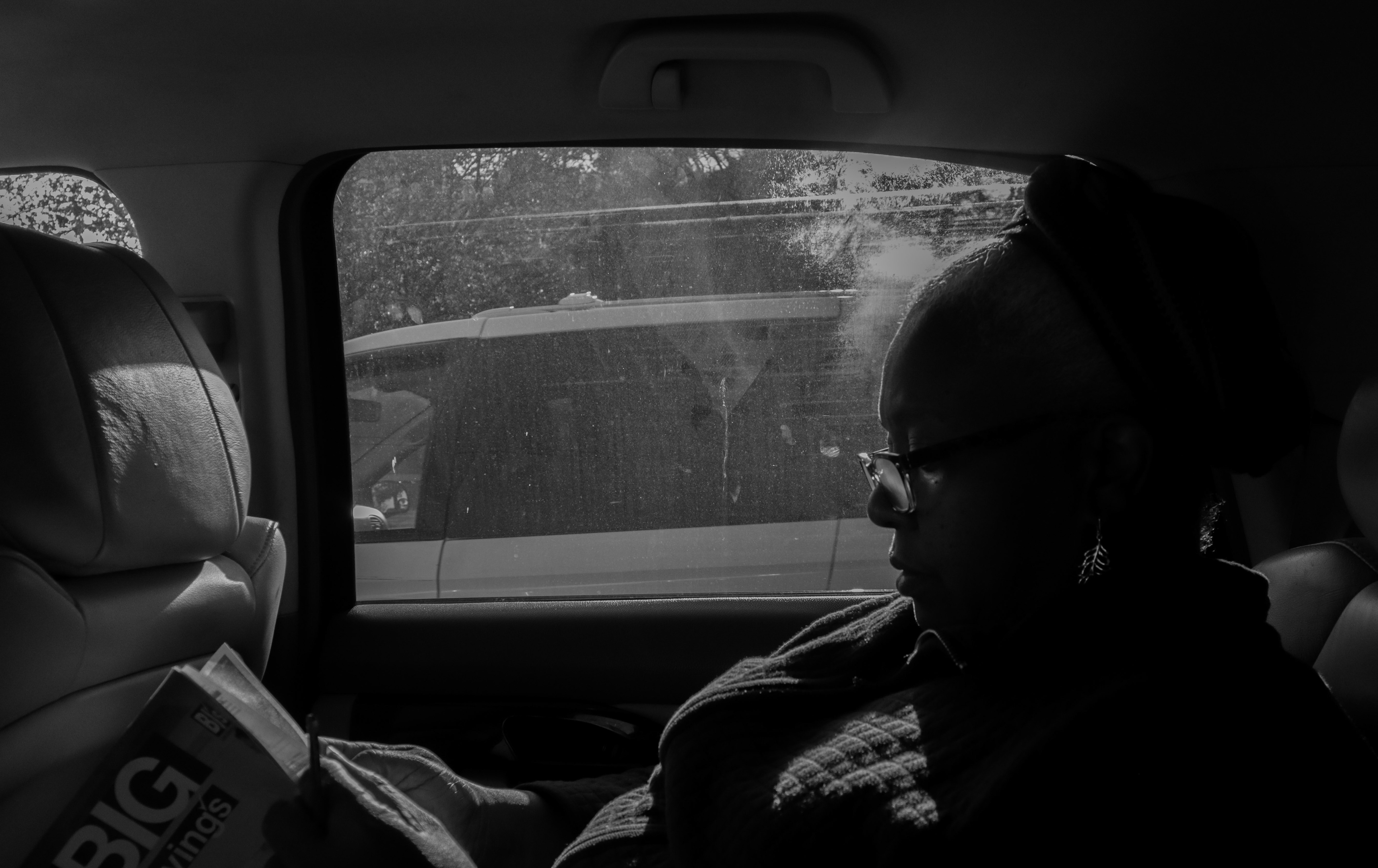 Myrtho sits in the backseat of the car, flipping through a magazine of BJ's coupons. The amount of items to purchase is substantial. Having a collection of coupons eases the burden and helps her save money when she purchases more essentials and perishables.