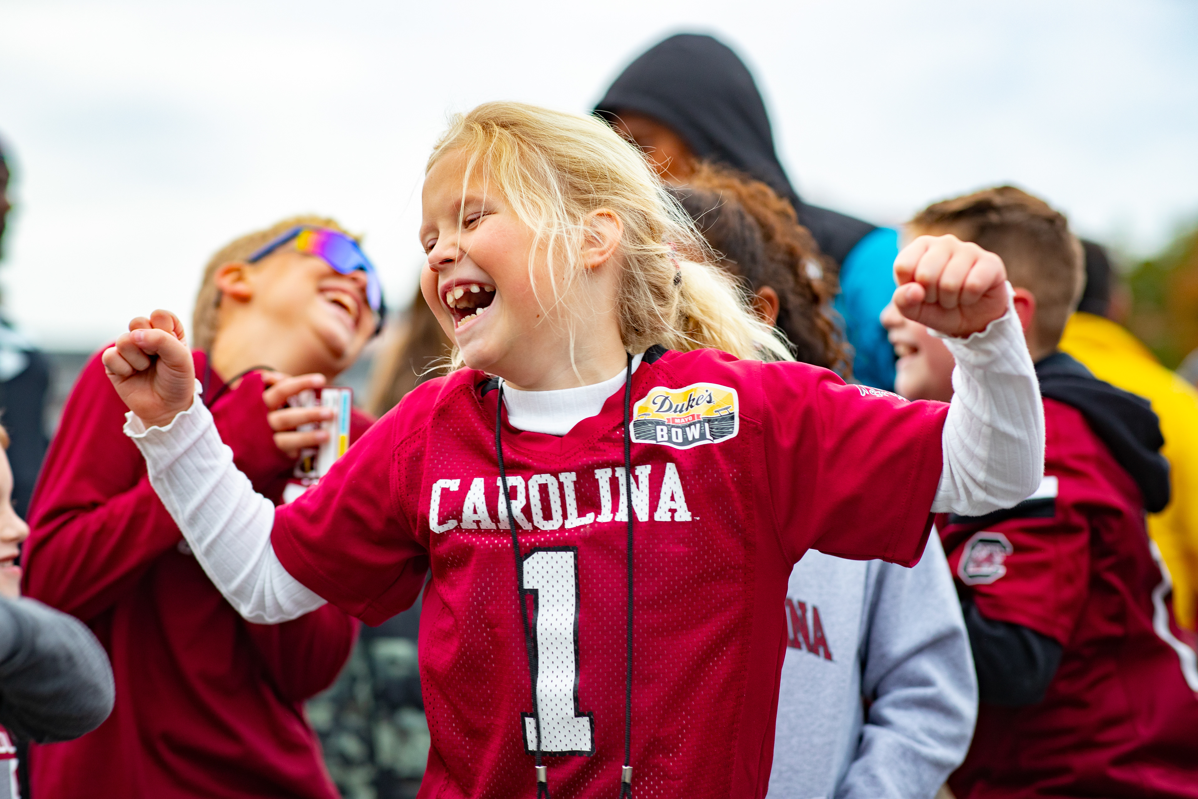 A young Gamecock fan dances as the Carolina Band marches by..