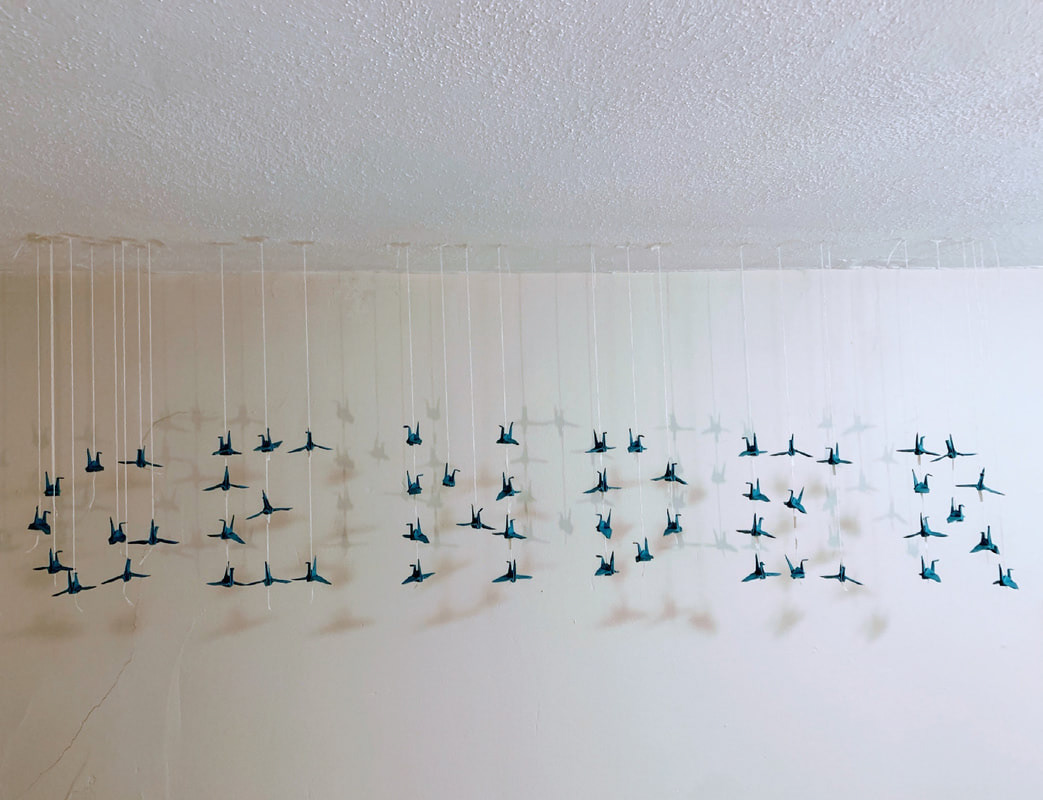 Legend says paper cranes can grant you a wish. This installation of paper cranes was a wish that gender was not imposed onto us.