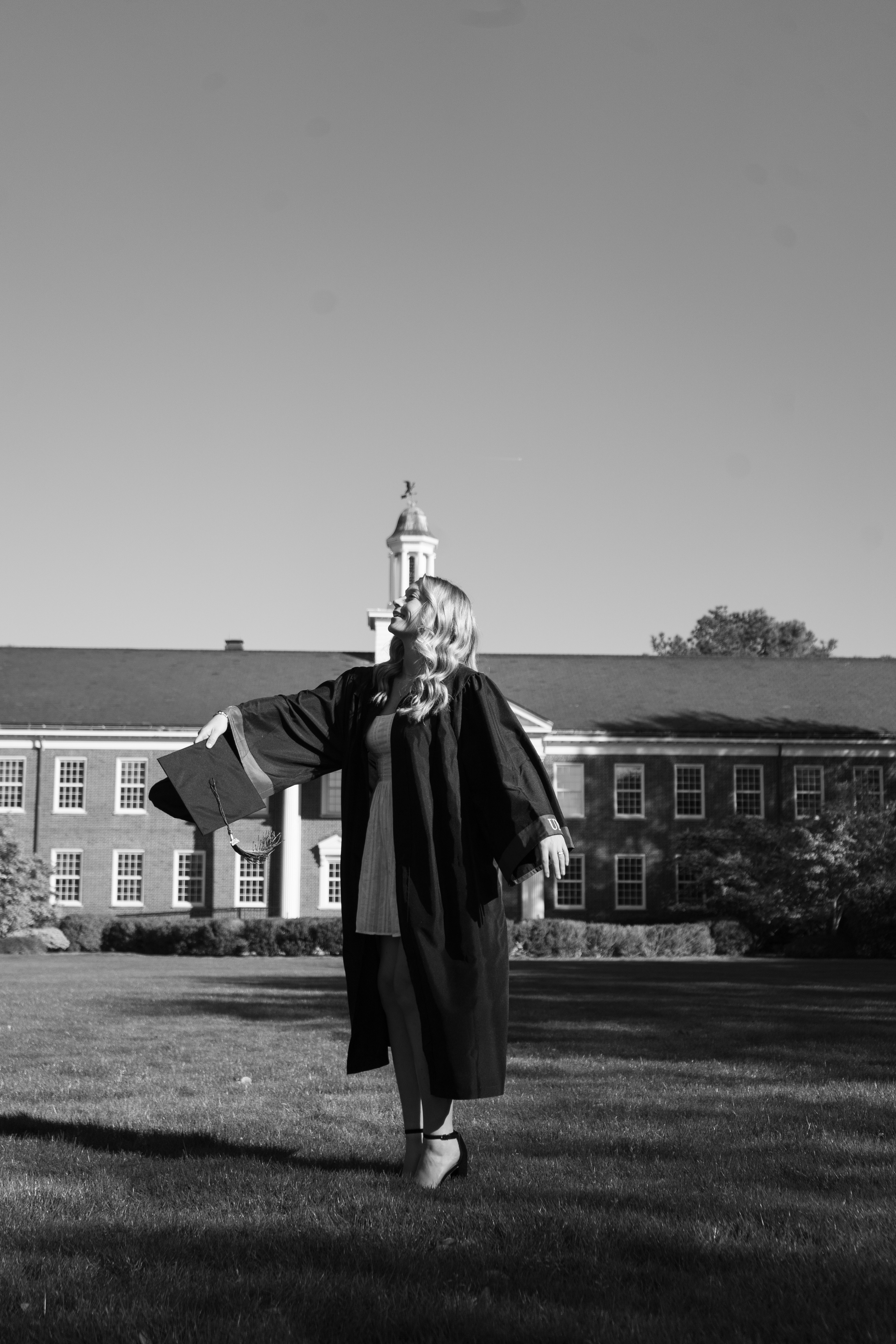 Ann Wallis throwing her cap up during a grad shoot