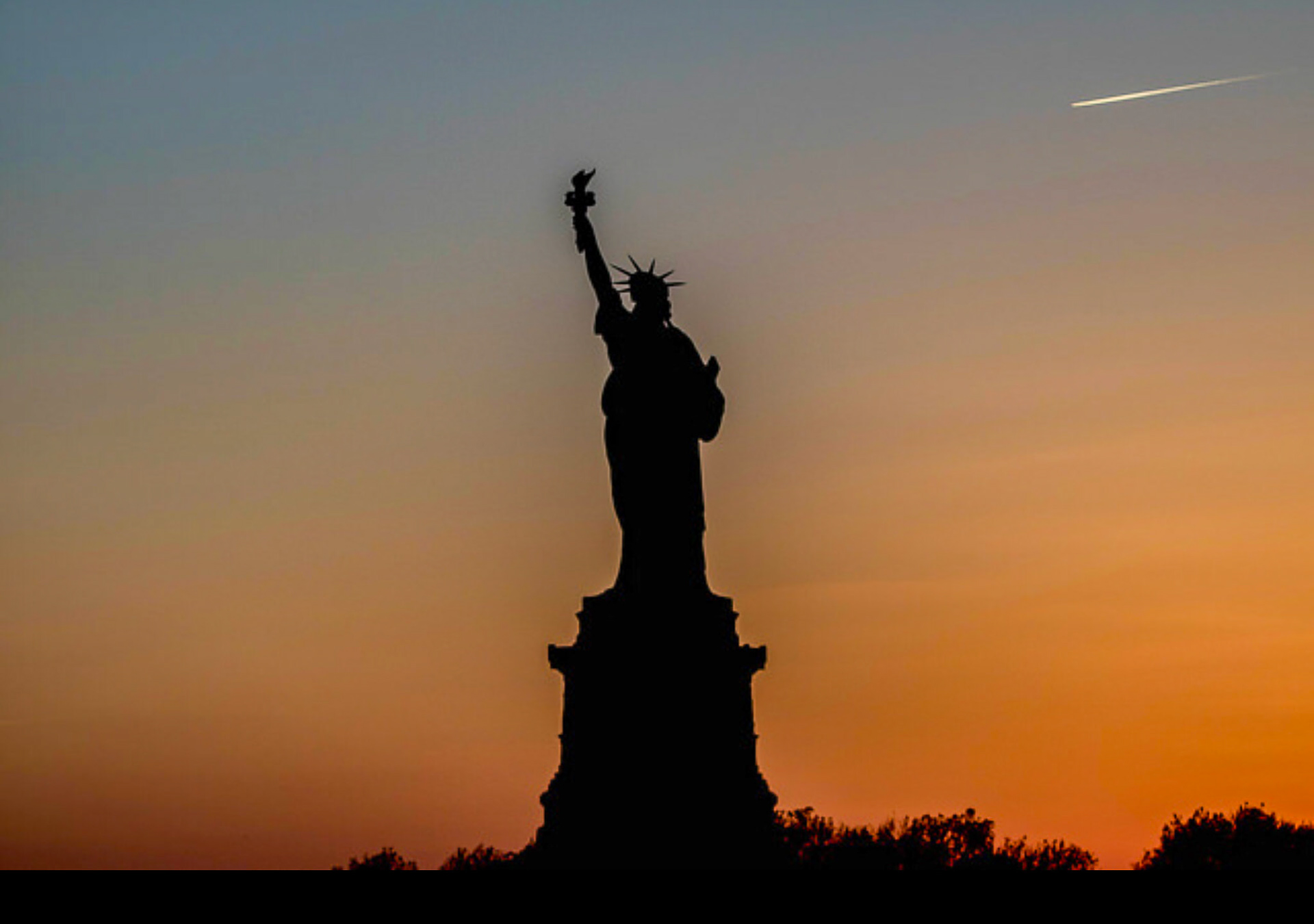 Sunset Cruise silhouette of Statue of Liberty.