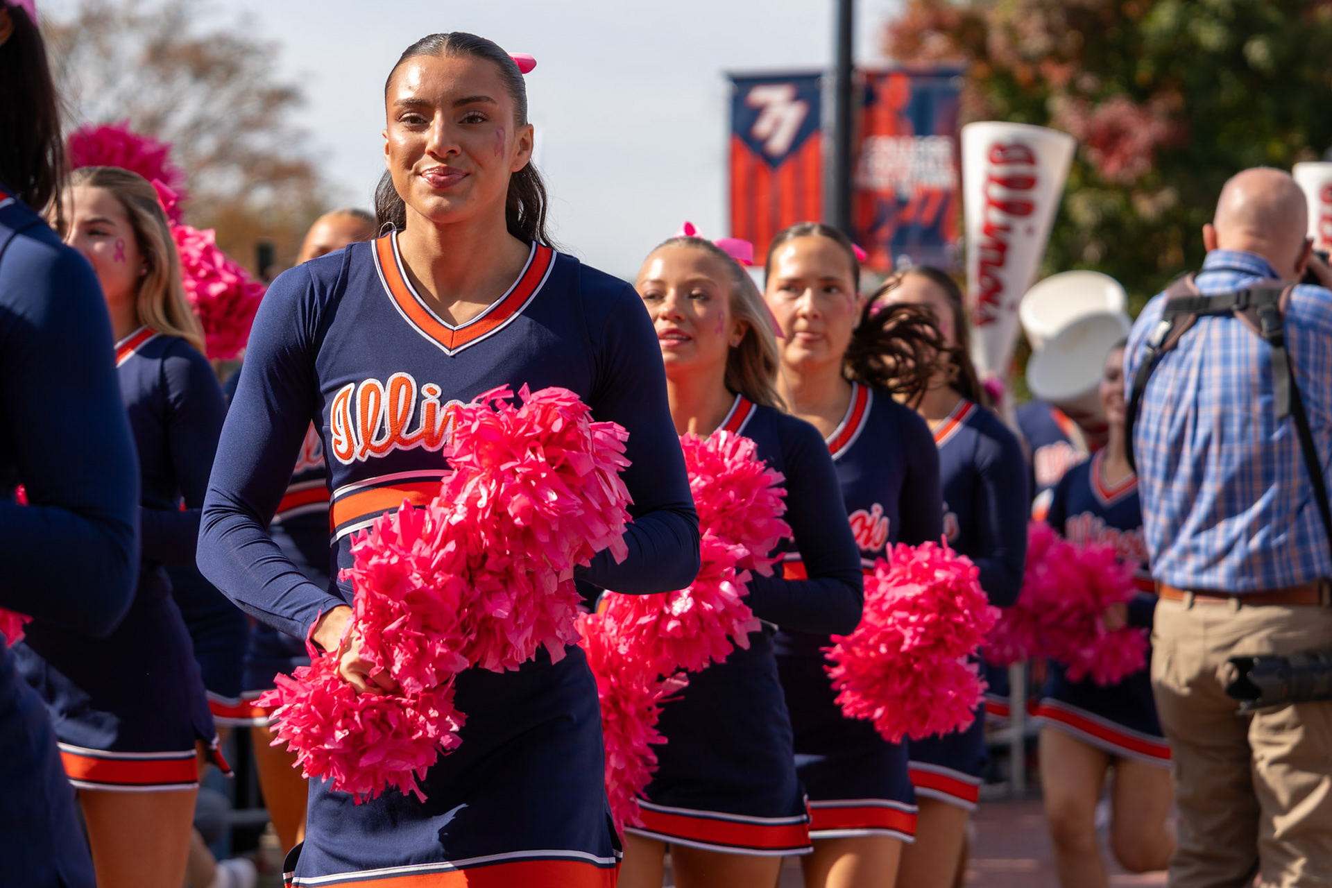 Illinois cheerleaders walk through Grange Grove ahead of the players during the Illini Walk before the team’s game against Oregon at Gies Memorial Stadium on Oct. 24, 2026. The Illini defeated the Ducks 21-10 in front of 58,723 fans.
