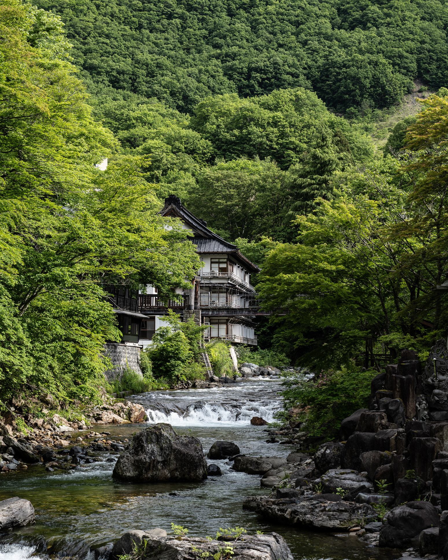 Looking upstream - seeing a small part of the First Annex, the Main Hall and the suspension bridge - at Takaragawa Onsen - photo Martin Kaufmann