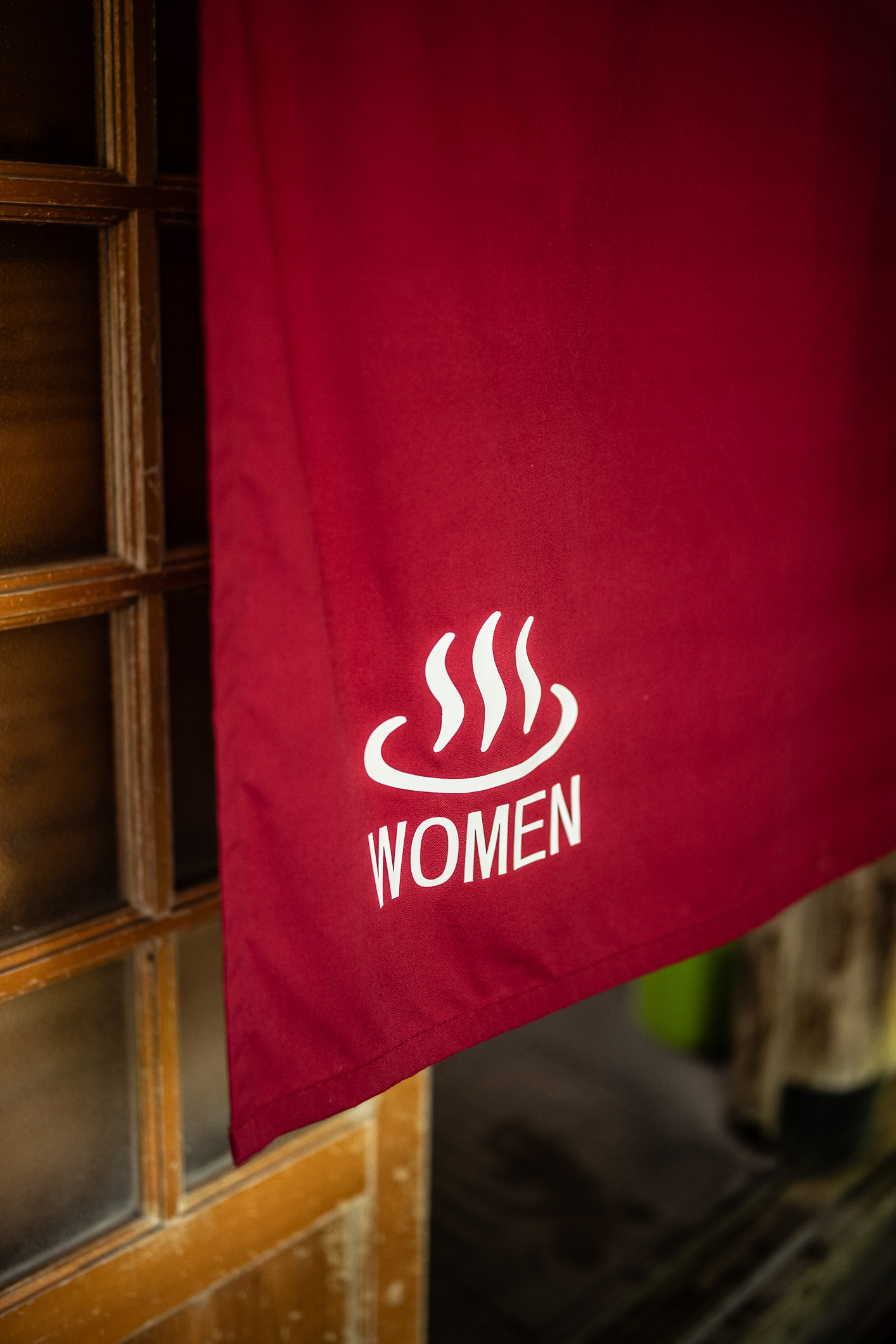 Red noren (curtain) showing the entrance to women bathing room at Takaragawa Onsen