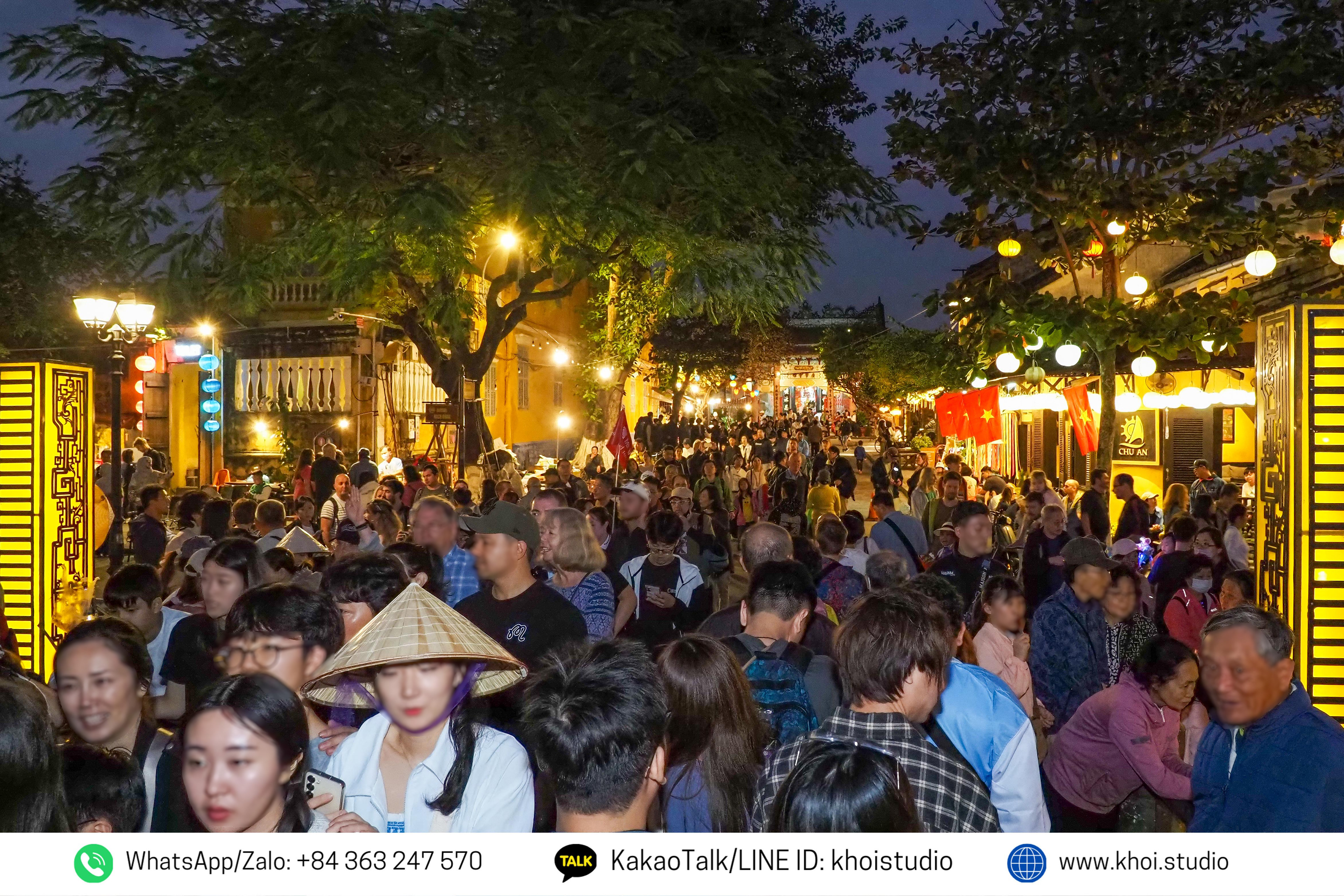 Crowds of tourists crowd across An Hoi Bridge in Hoi An at night.