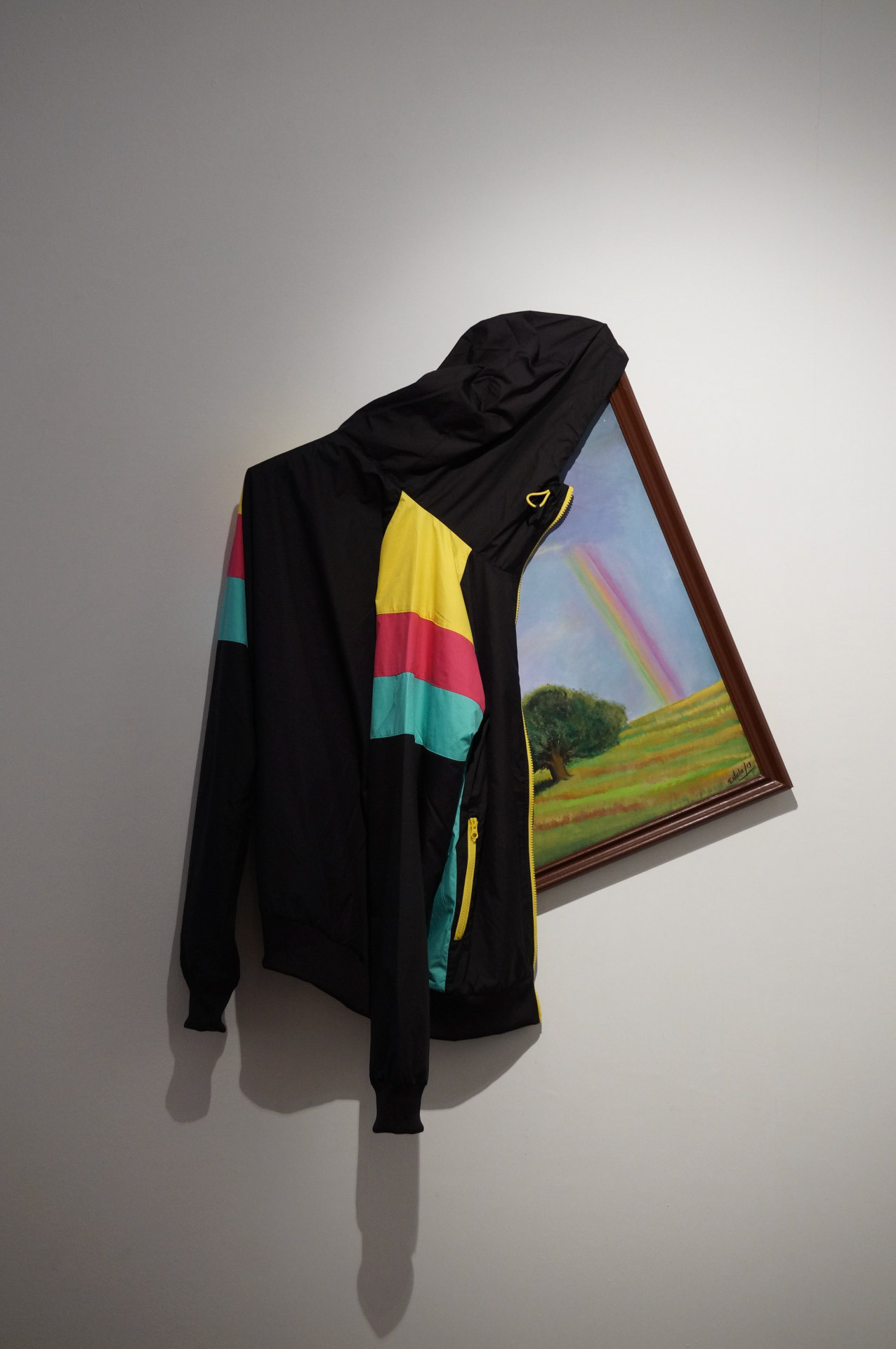 Posada. Instalación con pintura de habitación de posada y campera (track jacket '90).  2015.  La apariencia de una habitación del interior de Córdoba ¿acaso puede ser engañada por un turista también del interior? Tanto el gesto de abrigar la pintura ajena colgada como el cuadro mismo son decorativos y aparecen entonces como verdades  naturales: ornamento y estancia , paisaje y geometría, mate y colaciones , abrigo y posada, interior y diseño. Sala Alsina FNA, "La imposibilidad de nombrar lo que se mueve"