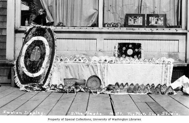Display of Alaska Native crafts and works of art on wooden sidewalk.