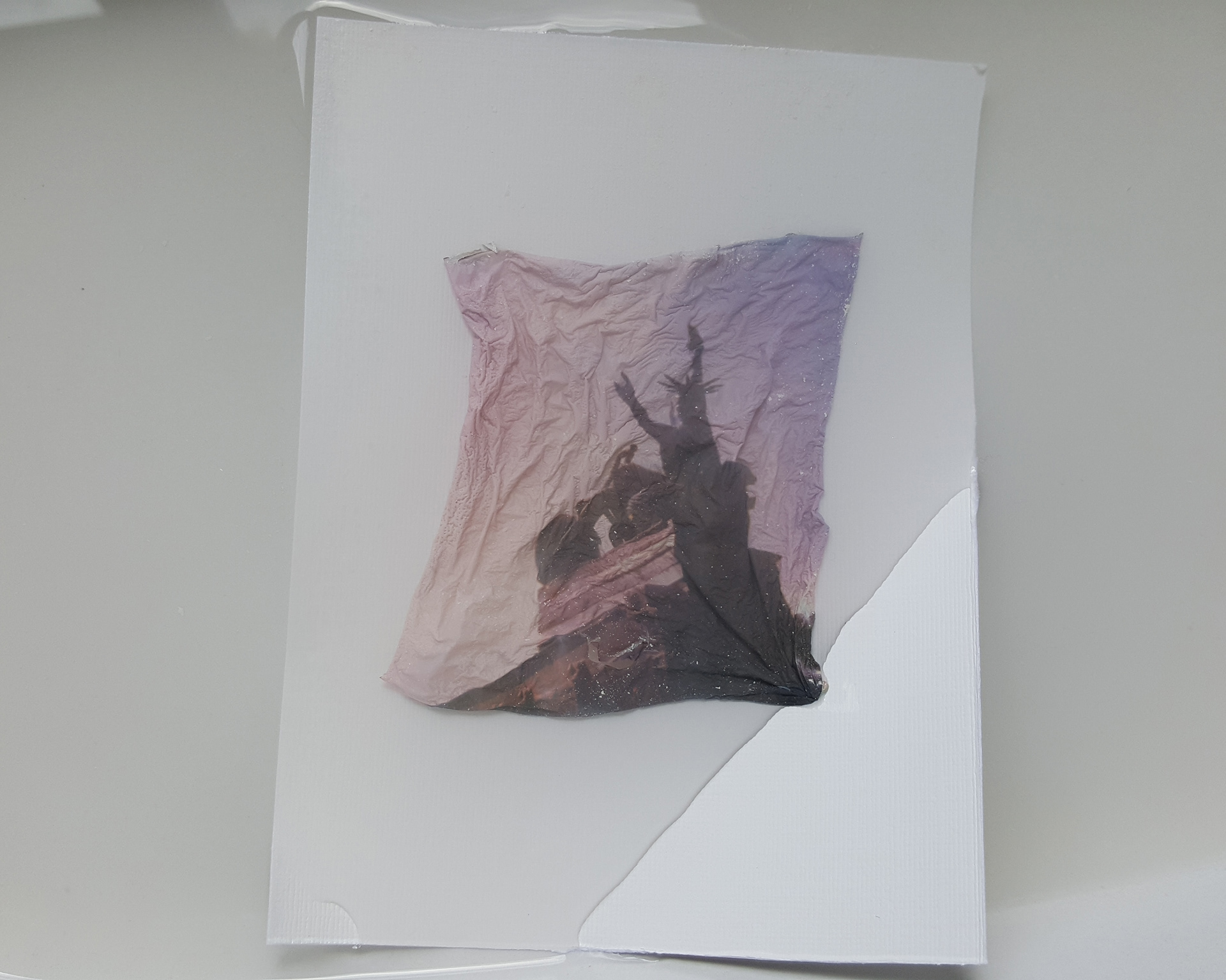 Once the film is free of the plastic you can slide a piece of the water colour paper under the image. Using the paint brushes to straighten out the film then gently hold onto two corners of the film and lift the paper from the water.