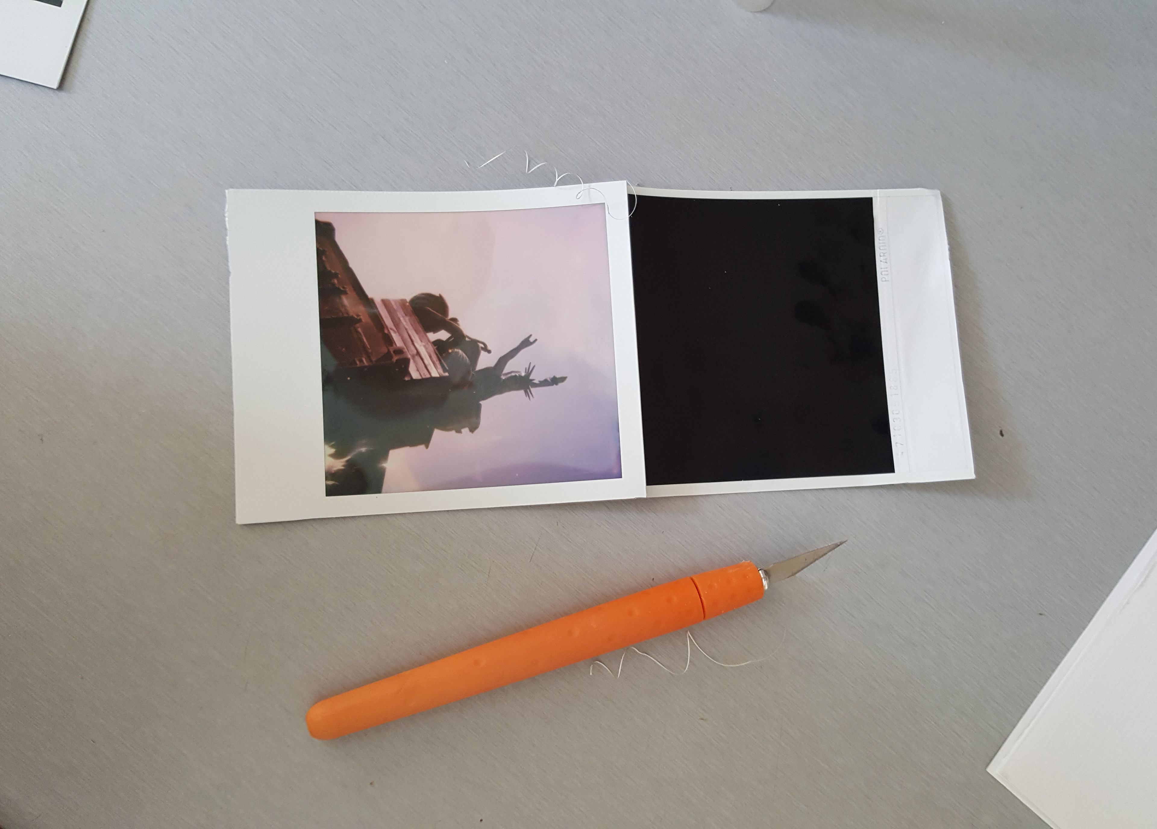  Using a sharp scalpel slice down the edges on three sides of the film, carefully!