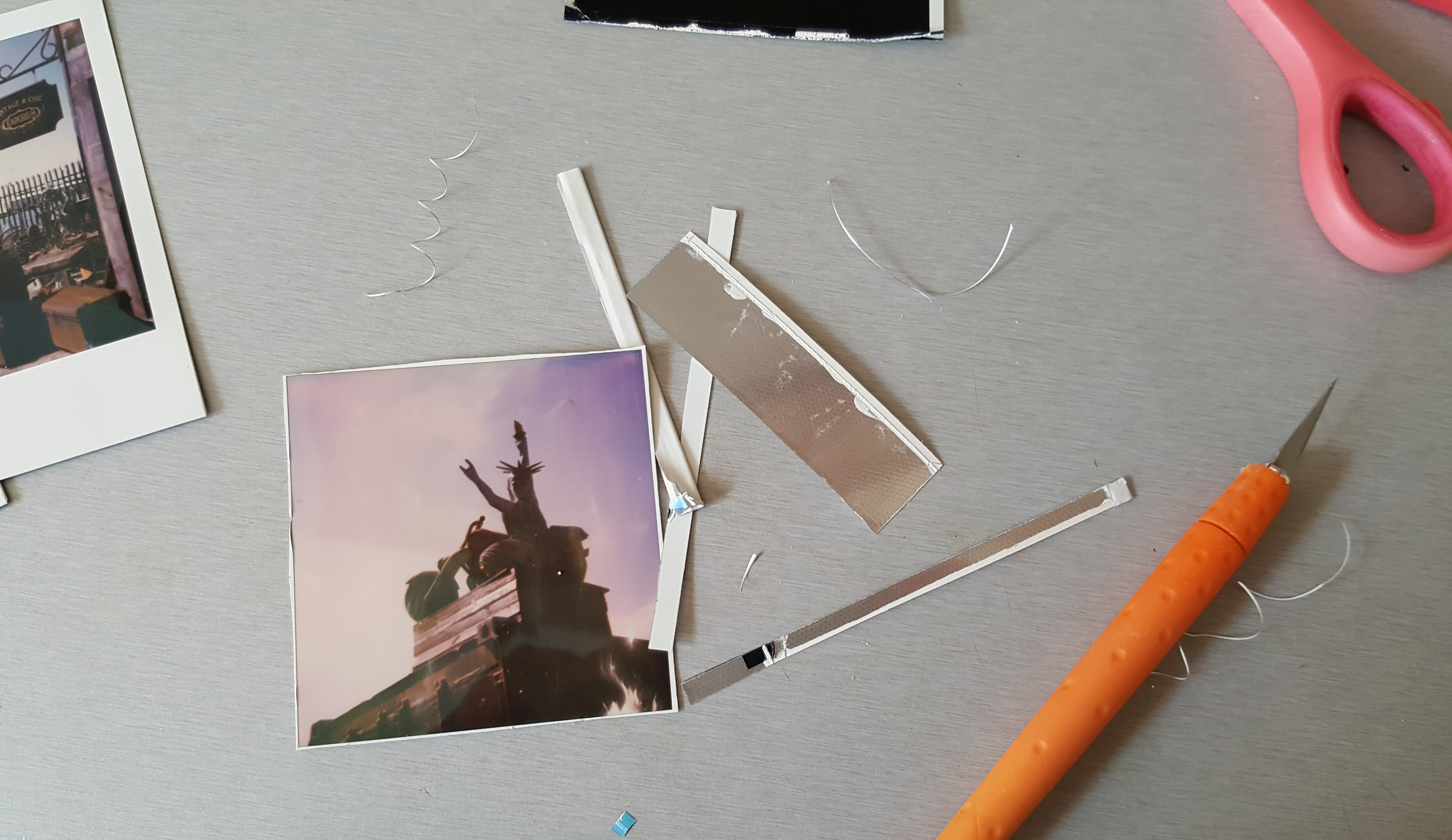 Open the wide end of the film and cut the little black tags on each side of the film.  Carefully peel back the front of the film from the black back and cut off the back with the scissors. You now have two pieces, you don't need the black back part so put it to one side. Trim the edges of the film leaving a small amount of white around the edge. Oh and boil the kettle.