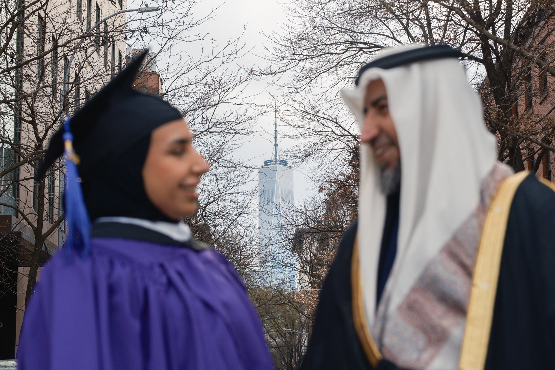 Candid graduation photography in NYC showing graduate enjoying the moment after earning master’s degree