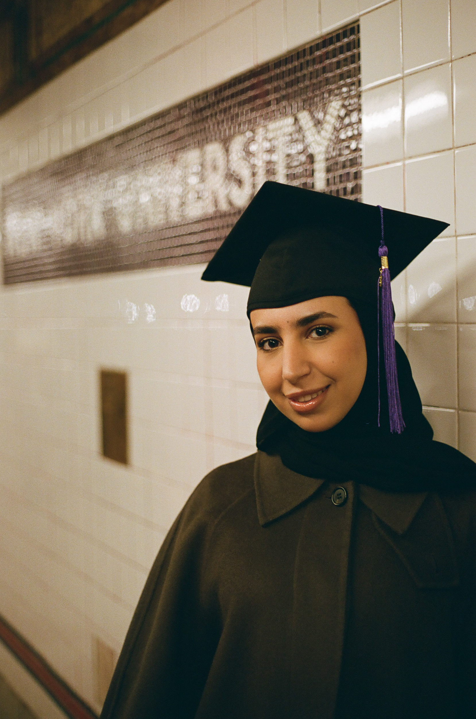 Documentary-style graduation portrait of NYU master’s graduate in New York City Subway