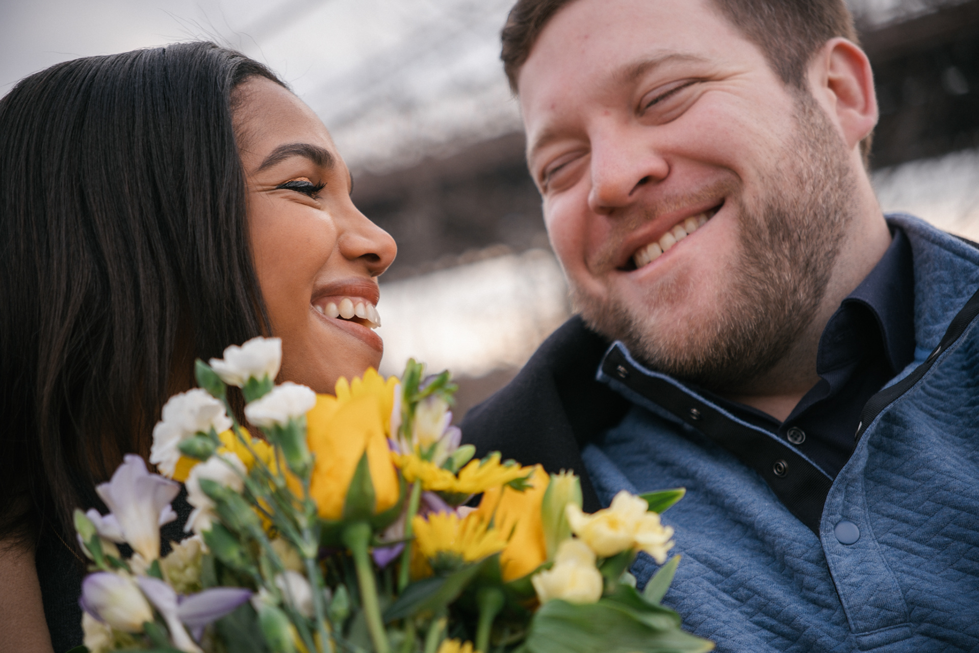 Natural light film photo of a couple sharing a quiet laugh during their engagement session in Dumbo.