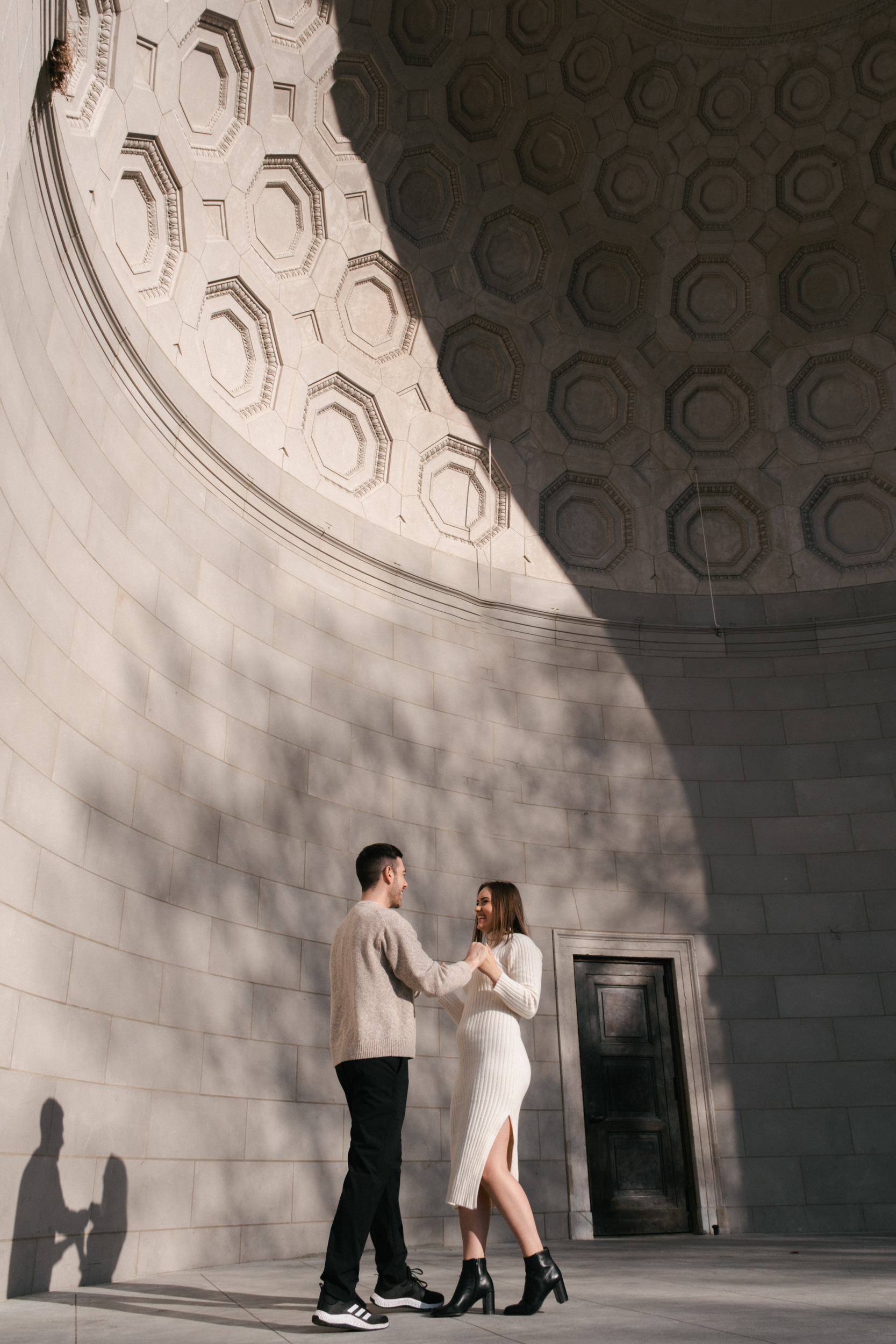 Candid photo of a couple dancing during their engagement session at the Literary Mall, Central Park, NYC
