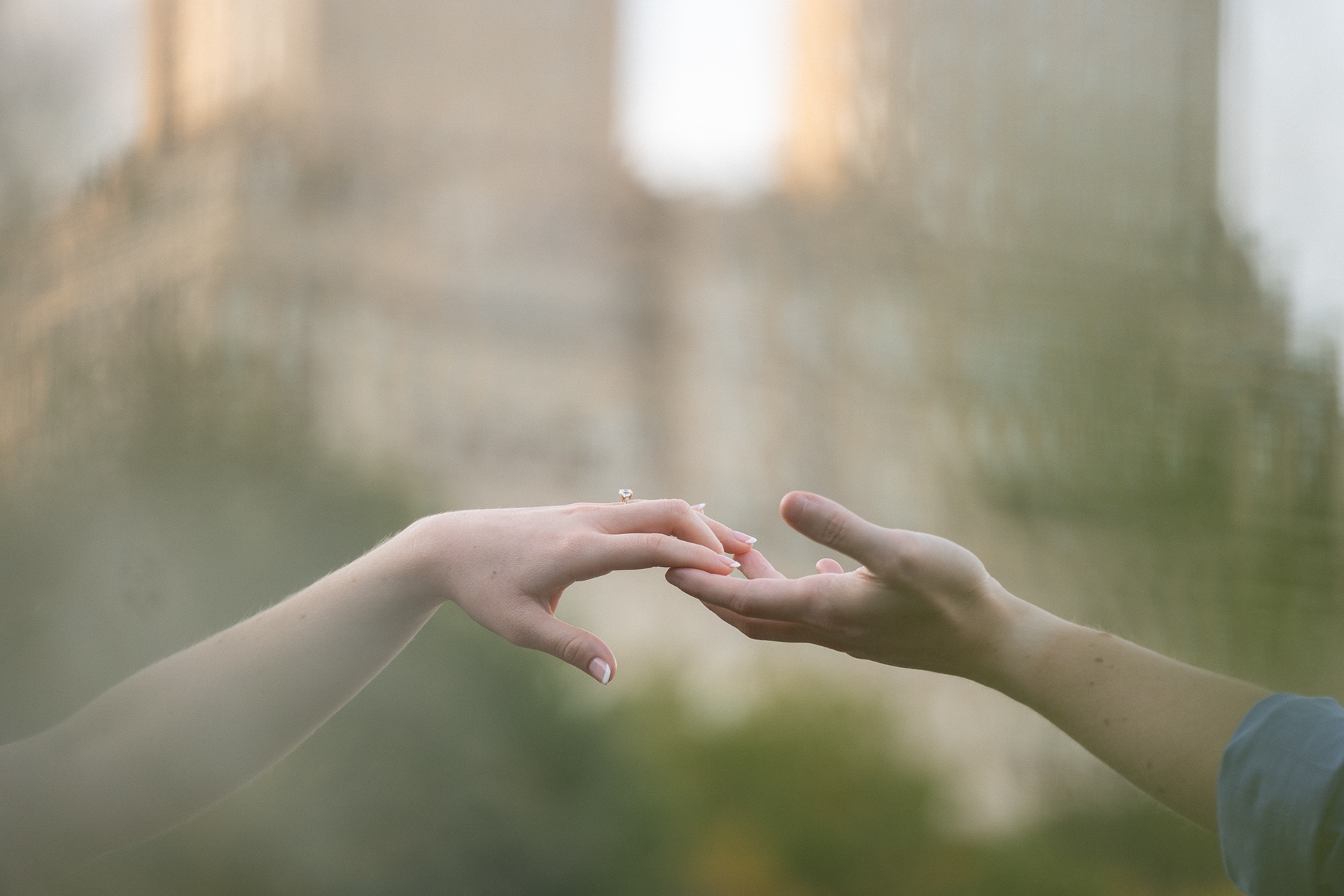 close up of a couple holding hands by the lake in Central Park during an engagement session
