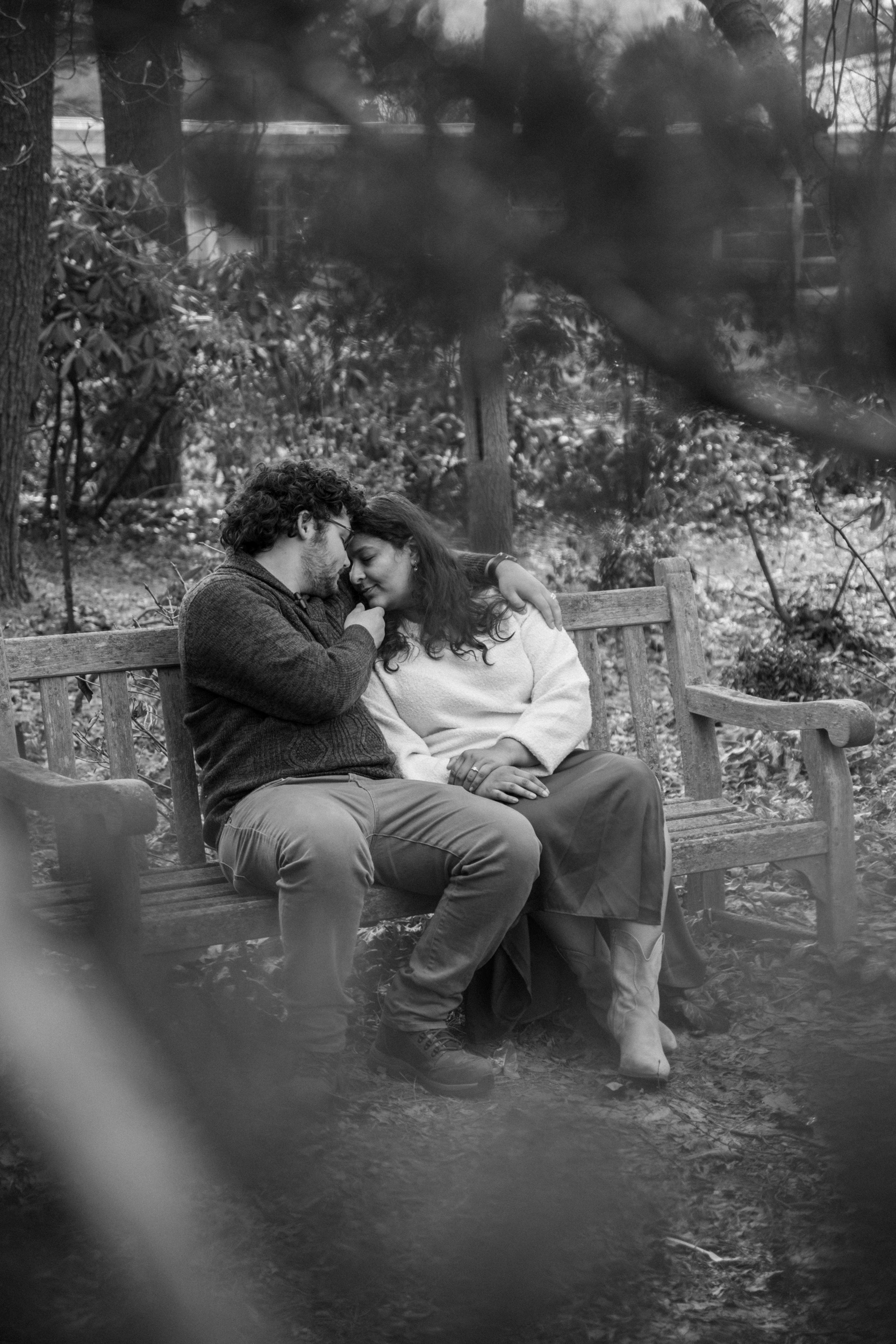 Black and white portrait of a couple on a park bench, shot on 35mm film.
