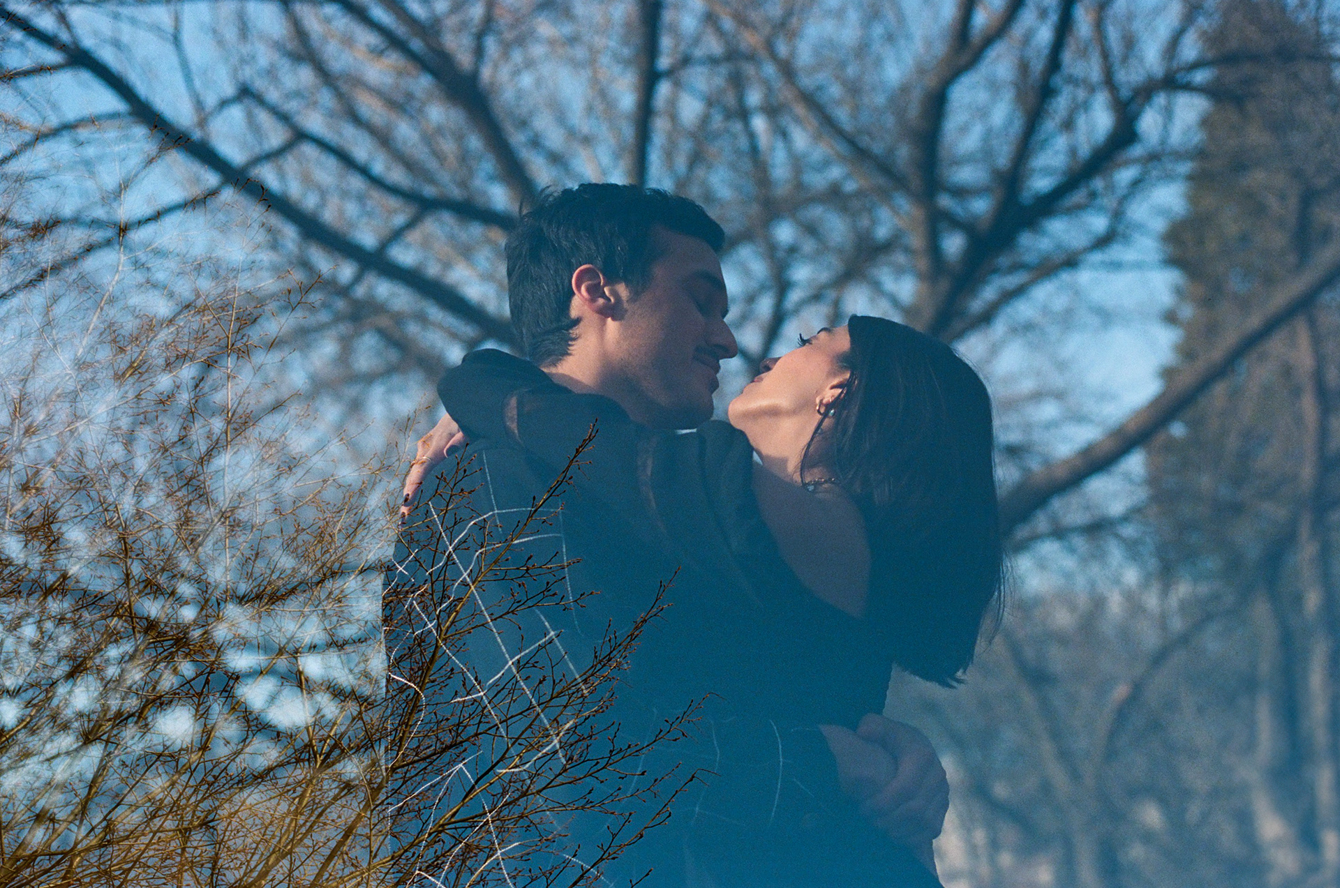 Double exposure portrait of engaged couple embracing under Brooklyn Botanical Garden