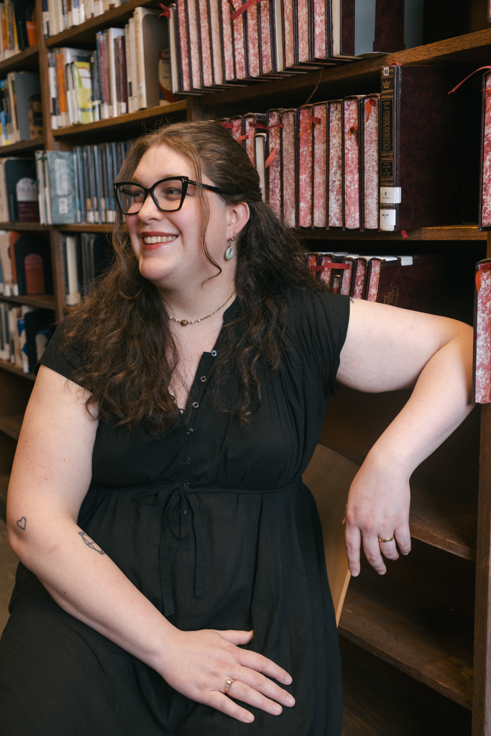 Queer author Madeline Trice posing for a photoshoot at Brooklyn Public Library