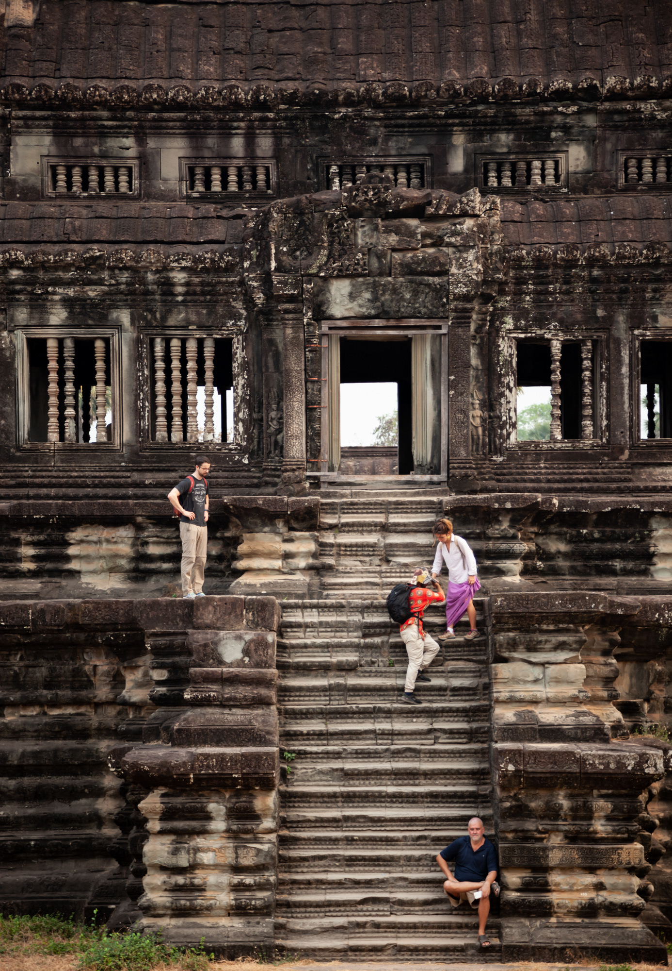 Tourists navigate the precarious stairs at Angkor Wat.