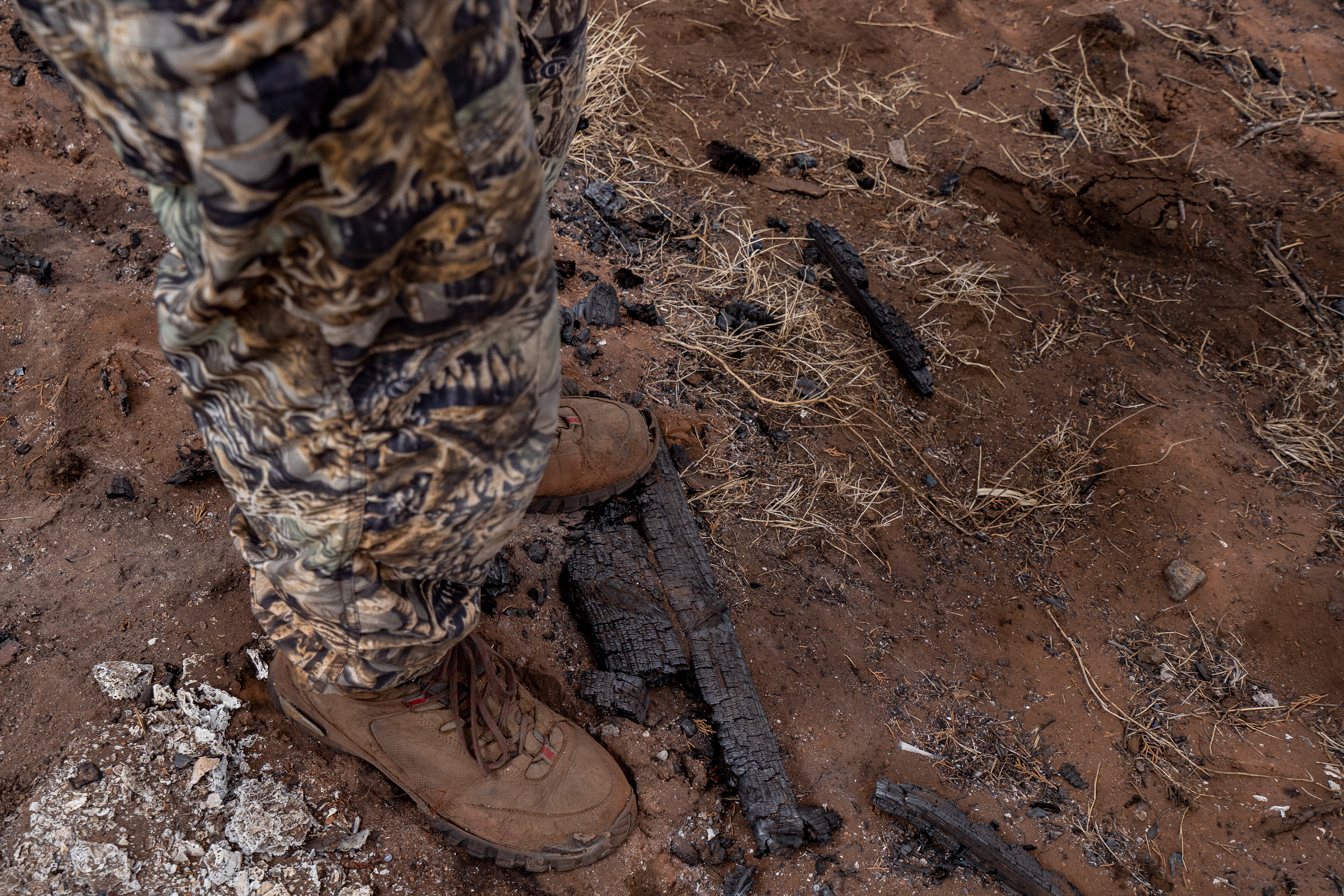 Kyle Ellison steps on some burned branches on Wednesday, Sept. 27, 2023, in Kula, Hawaii. (AP Photo/Mengshin Lin)  