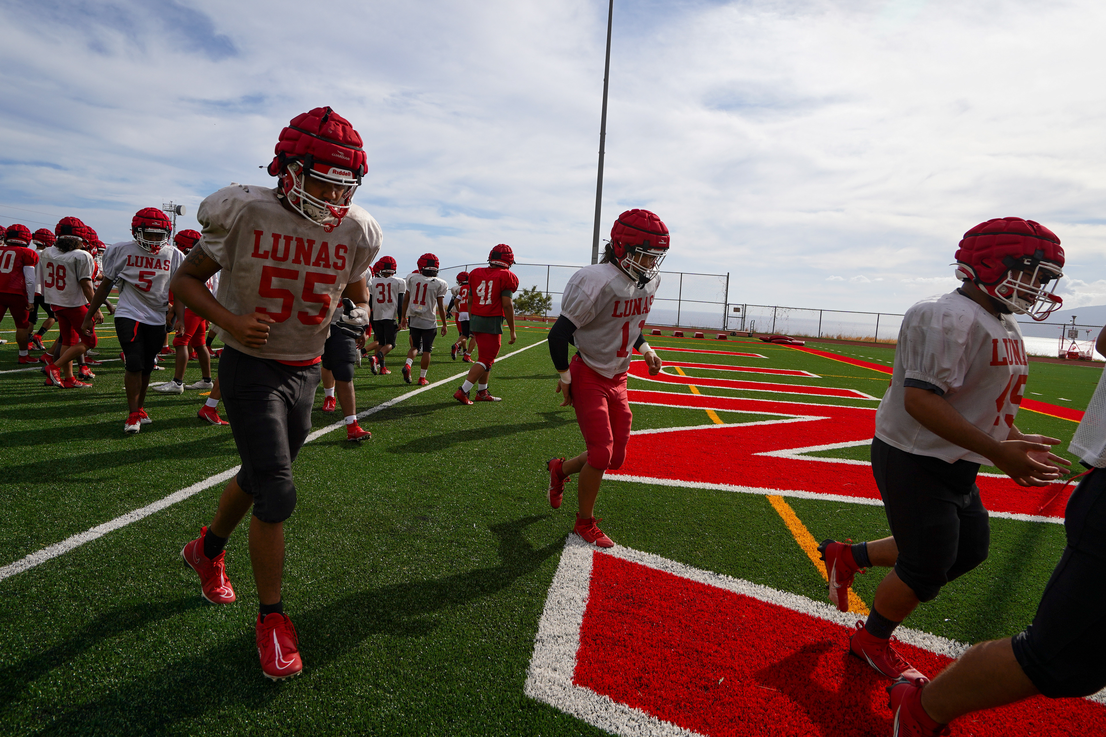 Lahainaluna football team run back to the field during their first week returning to practice on campus after August’s wildfire at Sue D. Cooley Stadium on Tuesday, Oct. 10, 2023, in Lahaina, Hawaii. (AP Photo/Mengshin Lin)