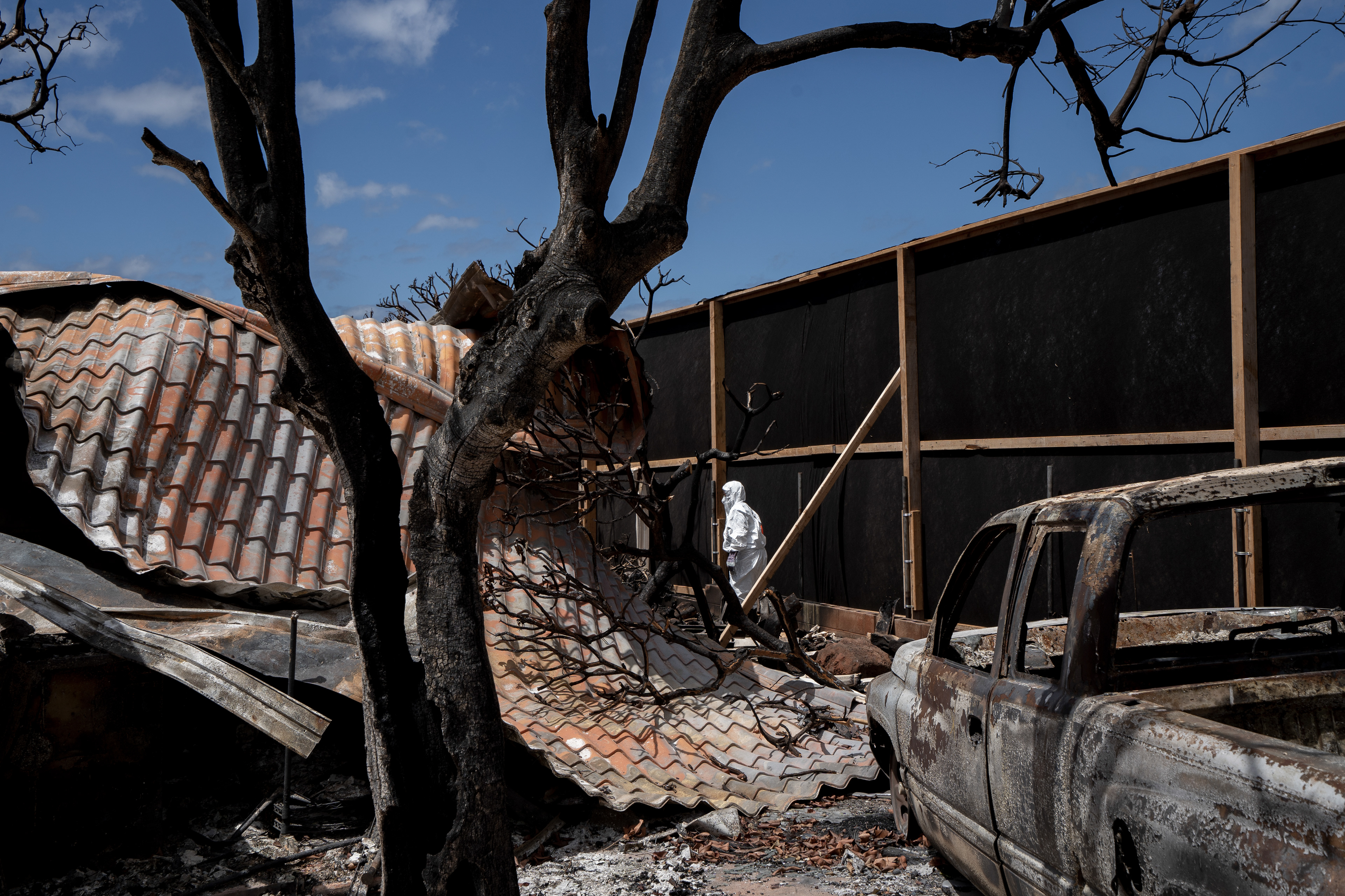 Leola Vera walks through her home the first time after the wildfire in August on Tuesday, Sept. 26, 2023, in Lahaina, Hawaii. The Veras are among the couple dozens are able to return to their property in Zone 1-C. (AP Photo/Mengshin Lin)  