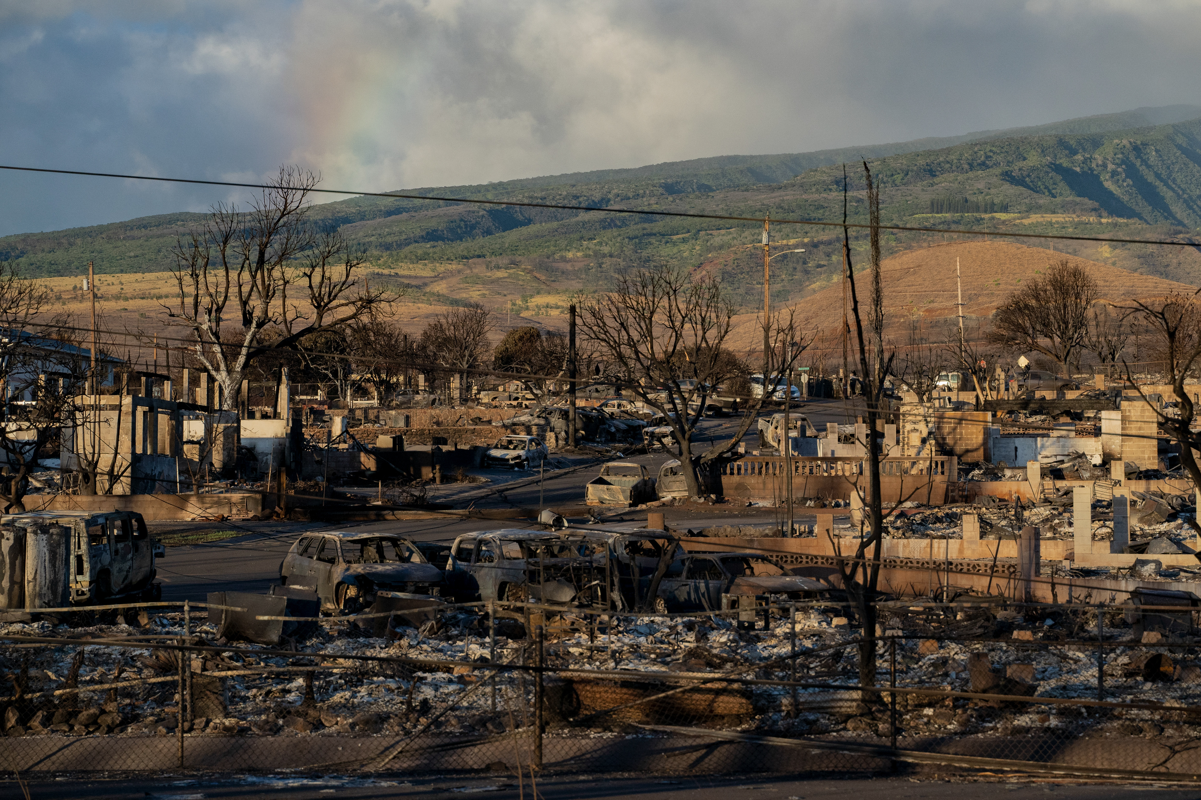 LAHAINA, HI - AUGUST 13: A rainbow is seen from Put Kukui mountain over burned cars and buildings in Lahaina, Hawaii on August 13, 2023. (Photo by Mengshin Lin for The Washington Post)