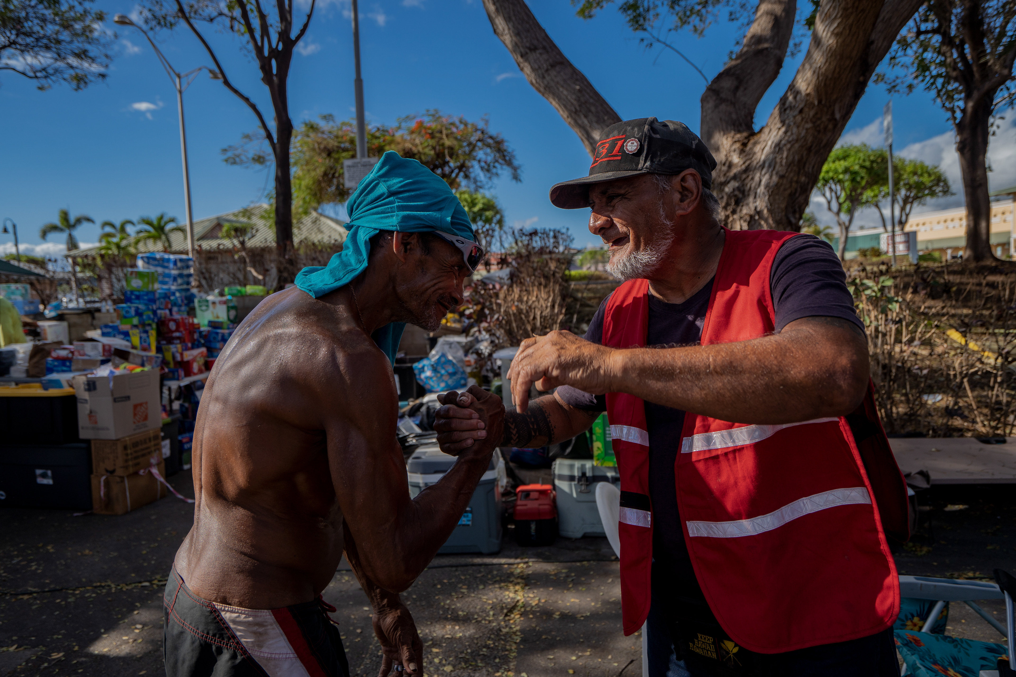LAHAINA, HI - AUGUST 13: Sifa Vea, left, hugs Keeaumoku Kapu after dropping off donations at Lahaina Gateway Center in Lahaina, Hawaii on August 13, 2023. (Photo by Mengshin Lin for The Washington Post)